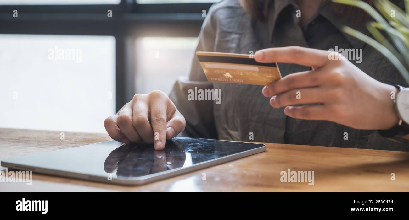 Achats en ligne. Femme asiatique saisissant des informations de carte de crédit par clavier de tablette pour faire des achats en ligne. Banque D'Images
