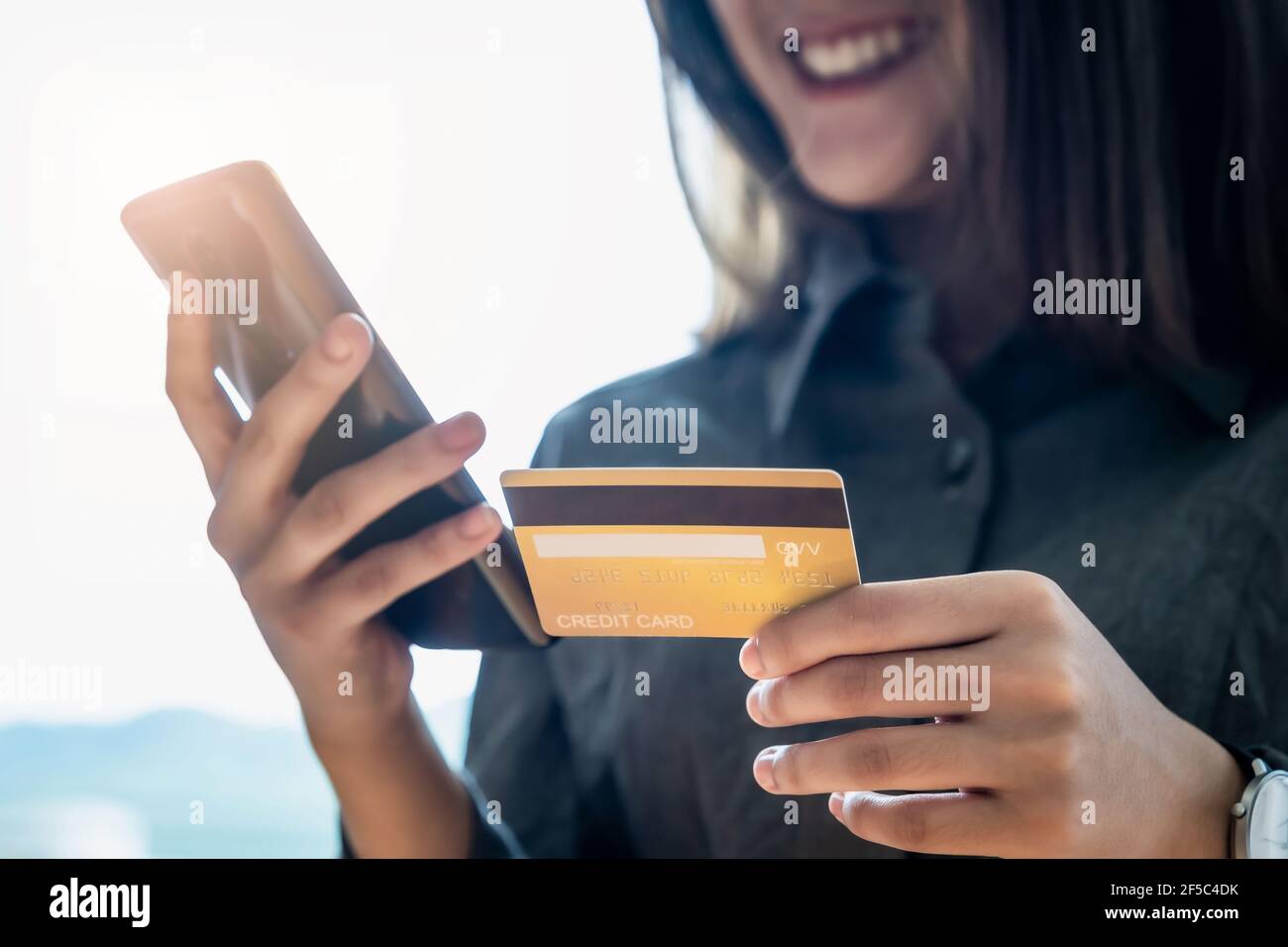 Achats en ligne. Femme asiatique saisissant des informations de carte de crédit par clavier de smartphone pour faire des achats en ligne. Banque D'Images