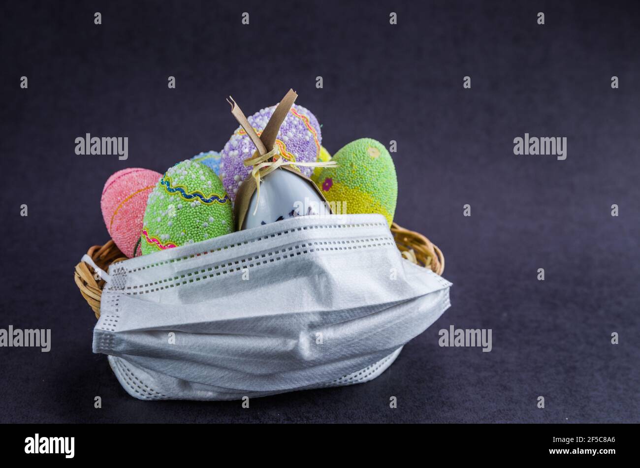 Pâques pendant la saison du SRAS-COV-2, COVID 19, panier de Pâques avec masque facial pour la protection contre les virus. Banque D'Images