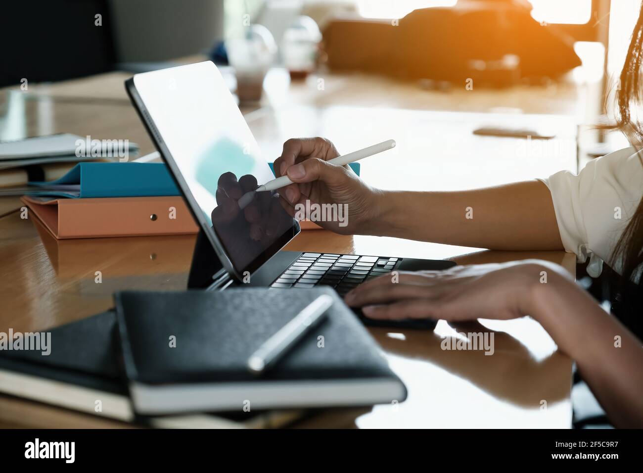 Homme d'affaires utilisant un stylo électronique pendant son travail, homme main utilisant un stylet avec une tablette tout en faisant des calculs financiers à son bureau. Banque D'Images