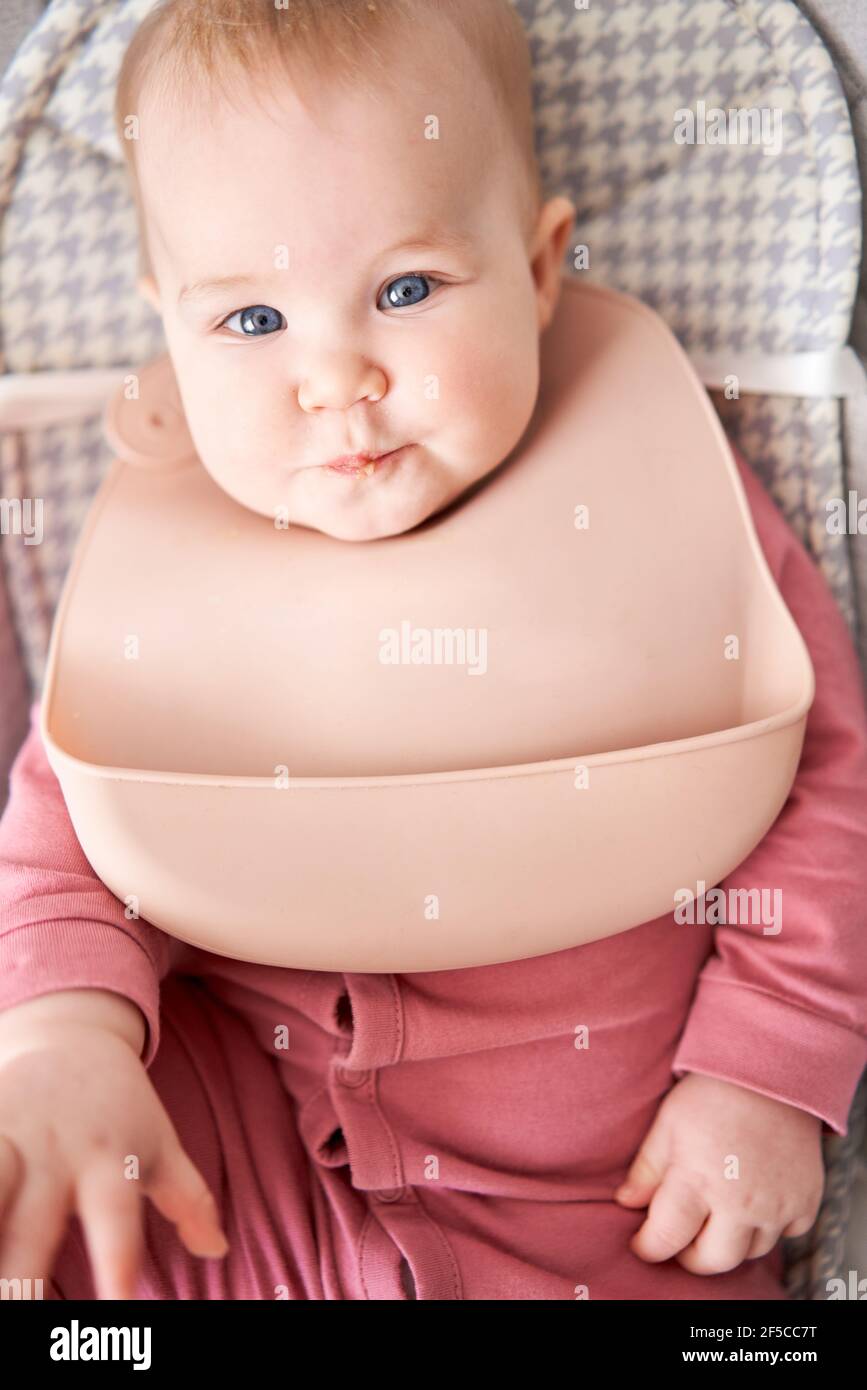 Portrait D Un Bebe Aux Levres Sales Une Jeune Mere Qui Nourrit Sa Petite Fille De Puree De Fruits Le Bebe A 7 Mois Allonge Dans Une Chaise Haute Speciale Photo Stock