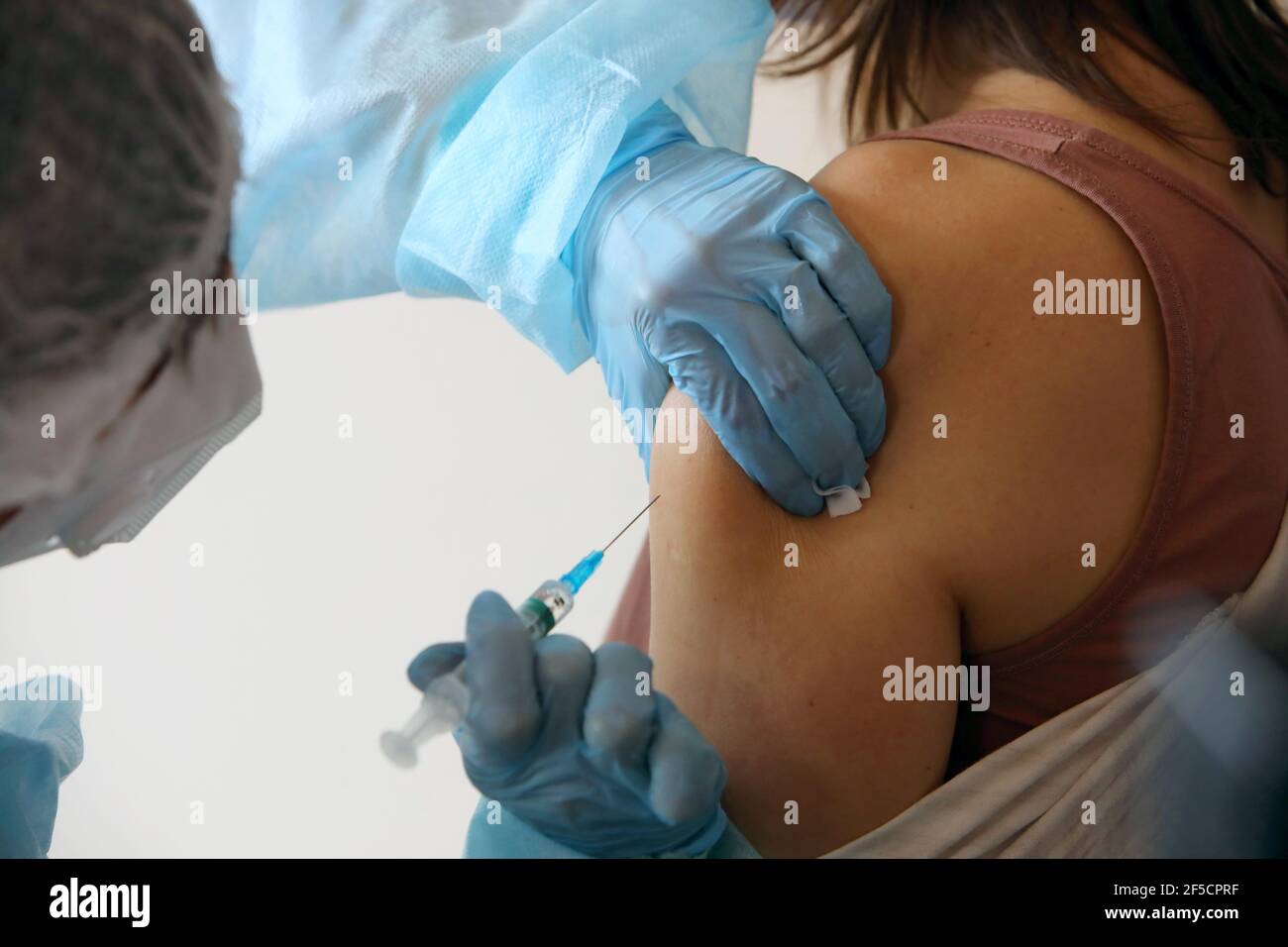 Non exclusif: KHARKIV, UKRAINE - 25 MARS 2021 - UN professionnel de la santé donne une dose du vaccin CoviShield à une femme à la police sanitaire de Kharkiv N2 Banque D'Images