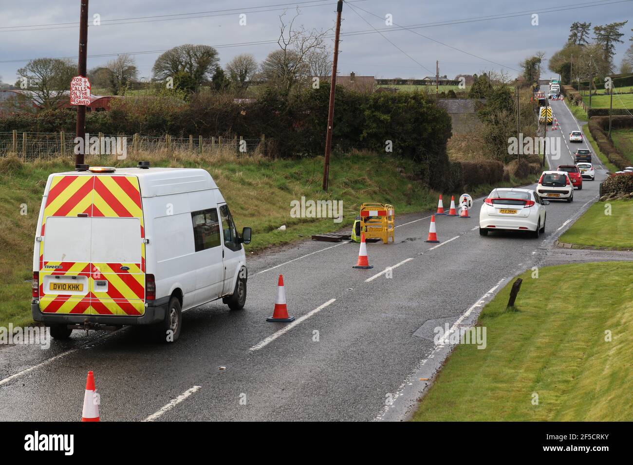 Les ouvriers installent un câble à fibre optique sous une route rurale à l'extérieur de Lisburn, en Irlande du Nord, au Royaume-Uni Banque D'Images