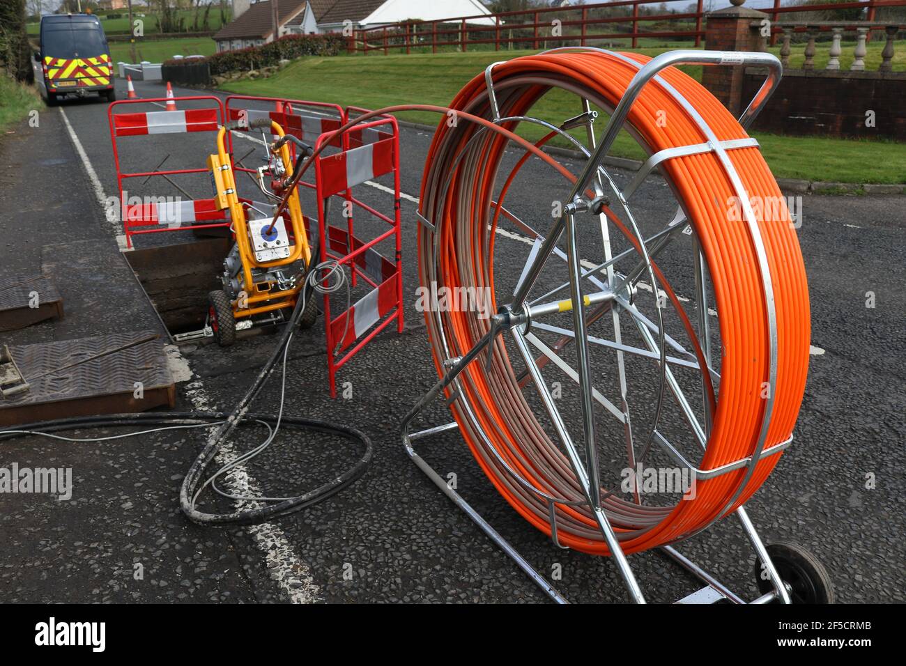 Une bobine de câble à fibre optique est introduite dans un trou d'homme lors de l'installation de câbles à fibre optique ruraux à l'extérieur de Lisburn, en Irlande du Nord, au Royaume-Uni Banque D'Images