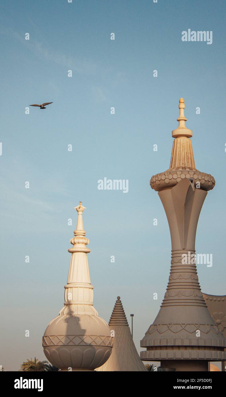 Photo verticale du café Dallah à Abu Dhabi sous le ciel clair avec un oiseau volant Banque D'Images
