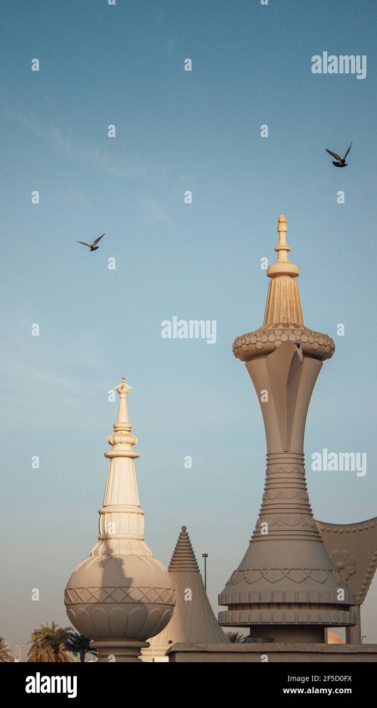 Photo verticale du café Dallah à Abu Dhabi sous le ciel clair avec un oiseau volant Banque D'Images