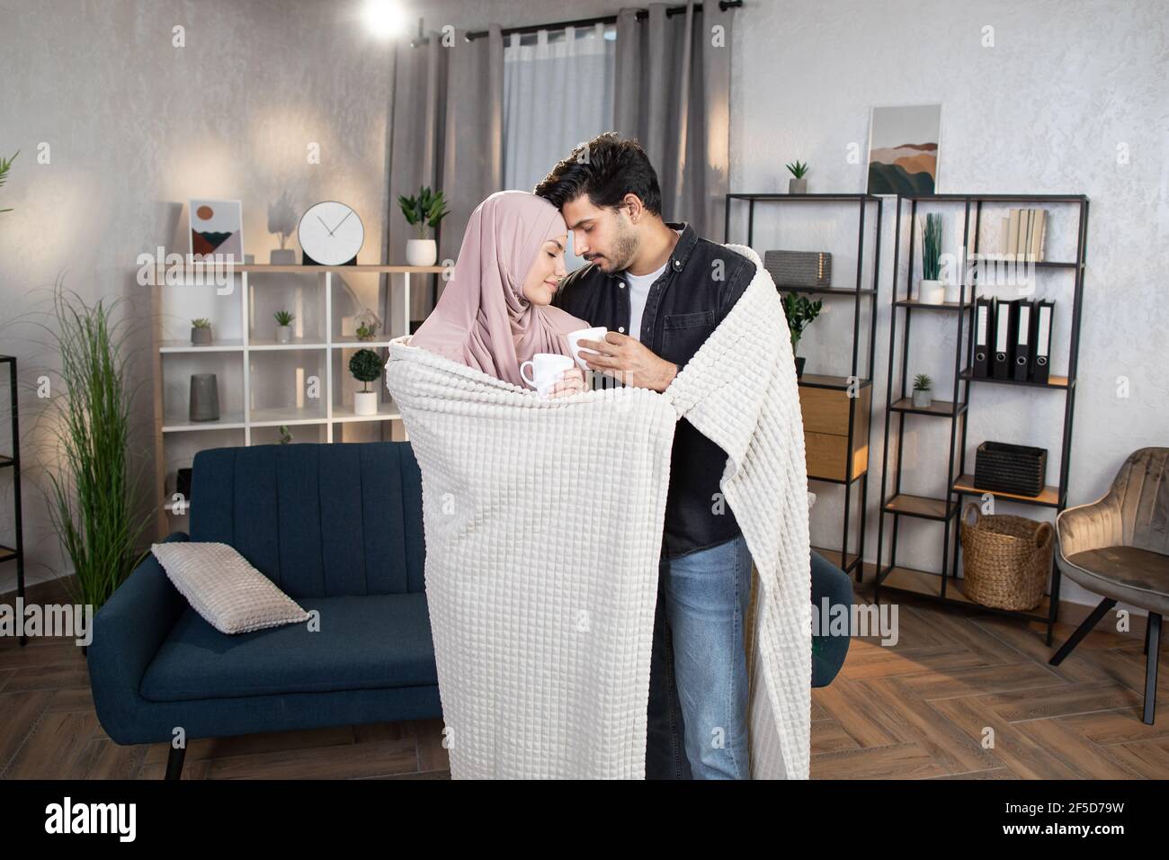 Portrait D Un Jeune Couple Arabe Amoureux Ensergeant Sous Une Couverture A La Maison Et Regardant L Un L Autre Touchant Les Fronts Buvant Du Cafe Ou Du The Concept De Famille Et De Relations