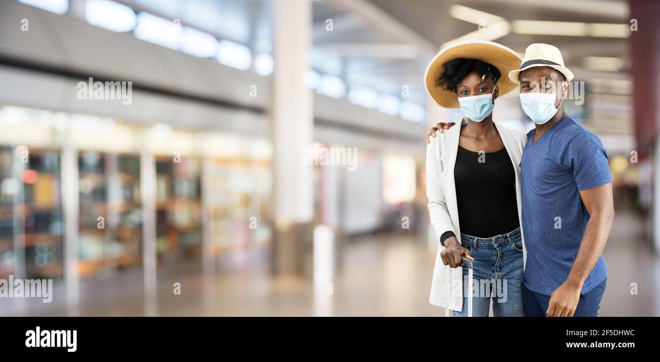 Un jeune couple africain en vacances à l'aéroport portant un masque facial Banque D'Images