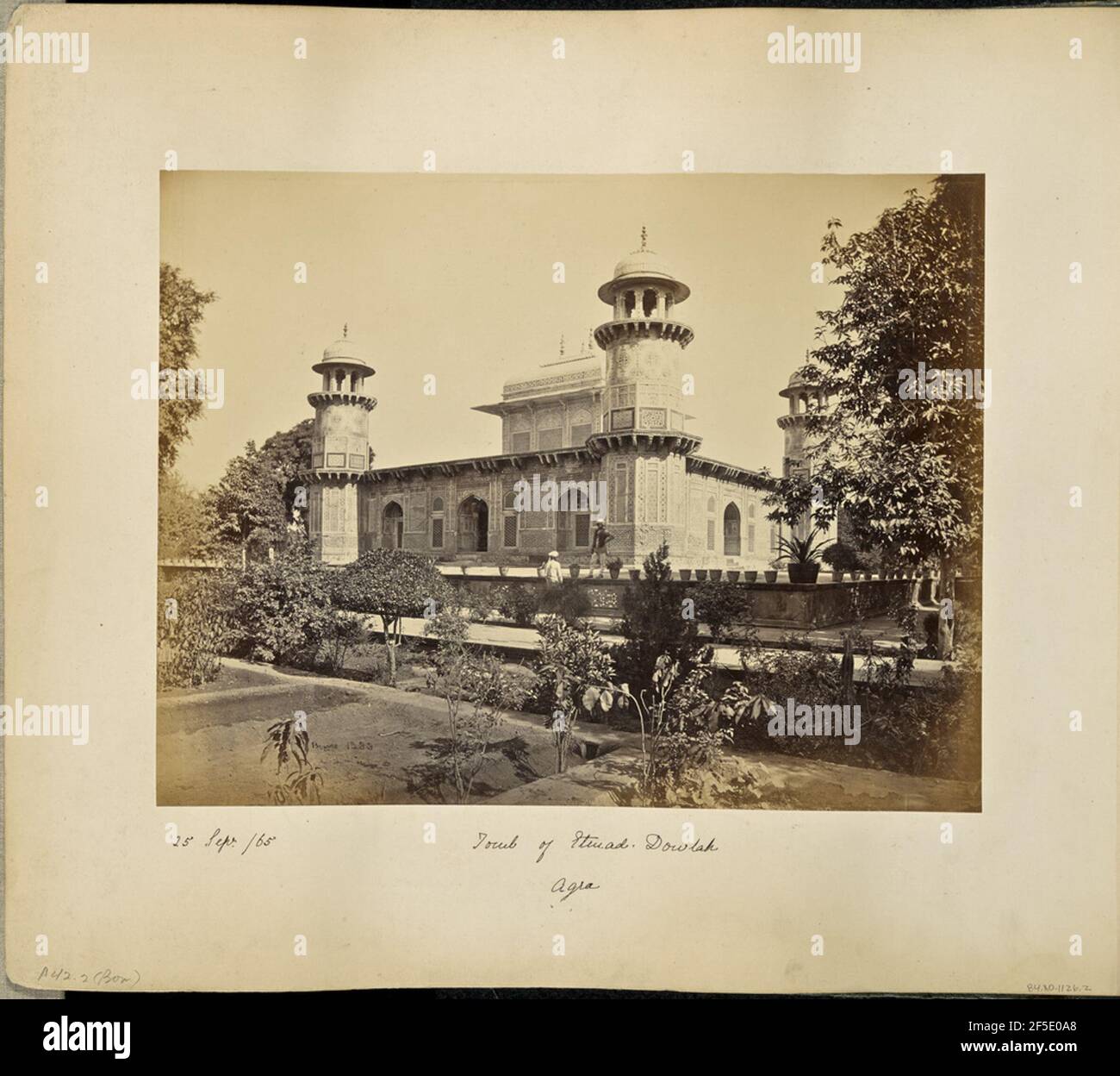 Agra; mausolée du Prince Etsmad-Dowlah, de la porte. Vue sur la tombe d'Itmad-UD-Daulah de l'autre côté des jardins autour de la porte. Trois des quatre tours sont visibles aux coins du bâtiment. Chaque tour est dotée de chattris ou de pavillons en forme de dôme décoratif, et le bâtiment est décoré de mosaïques à motifs très ornés. Deux hommes se tiennent dans le jardin, l'un sur la plate-forme surélevée qui entoure le tombeau, et l'autre sur le sol en dessous. (Recto, image) en bas à gauche, manuscrit en négatif: '1233' (Recto, mount) en bas à gauche, manuscrit en encre noire: '25 sept. /65' en bas à gauche, manuscrit en pe Banque D'Images
