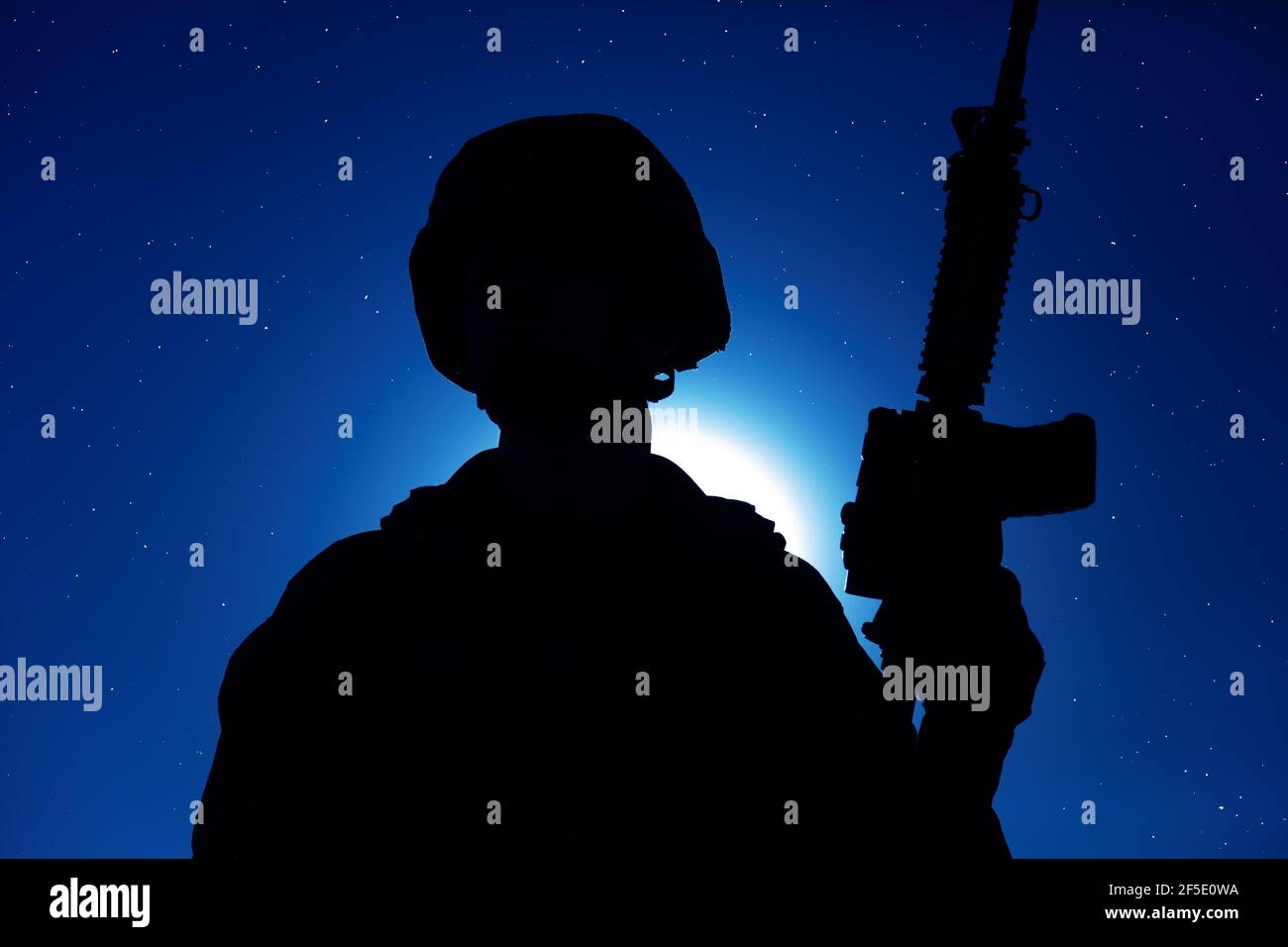 Silhouette nocturne des forces des opérations spéciales de l'armée soldat debout avec une carabine de service sur fond de ciel nocturne avec lune et étoiles. Combattant de guerre moderne en casque, Raider de Marines dans l'obscurité Banque D'Images