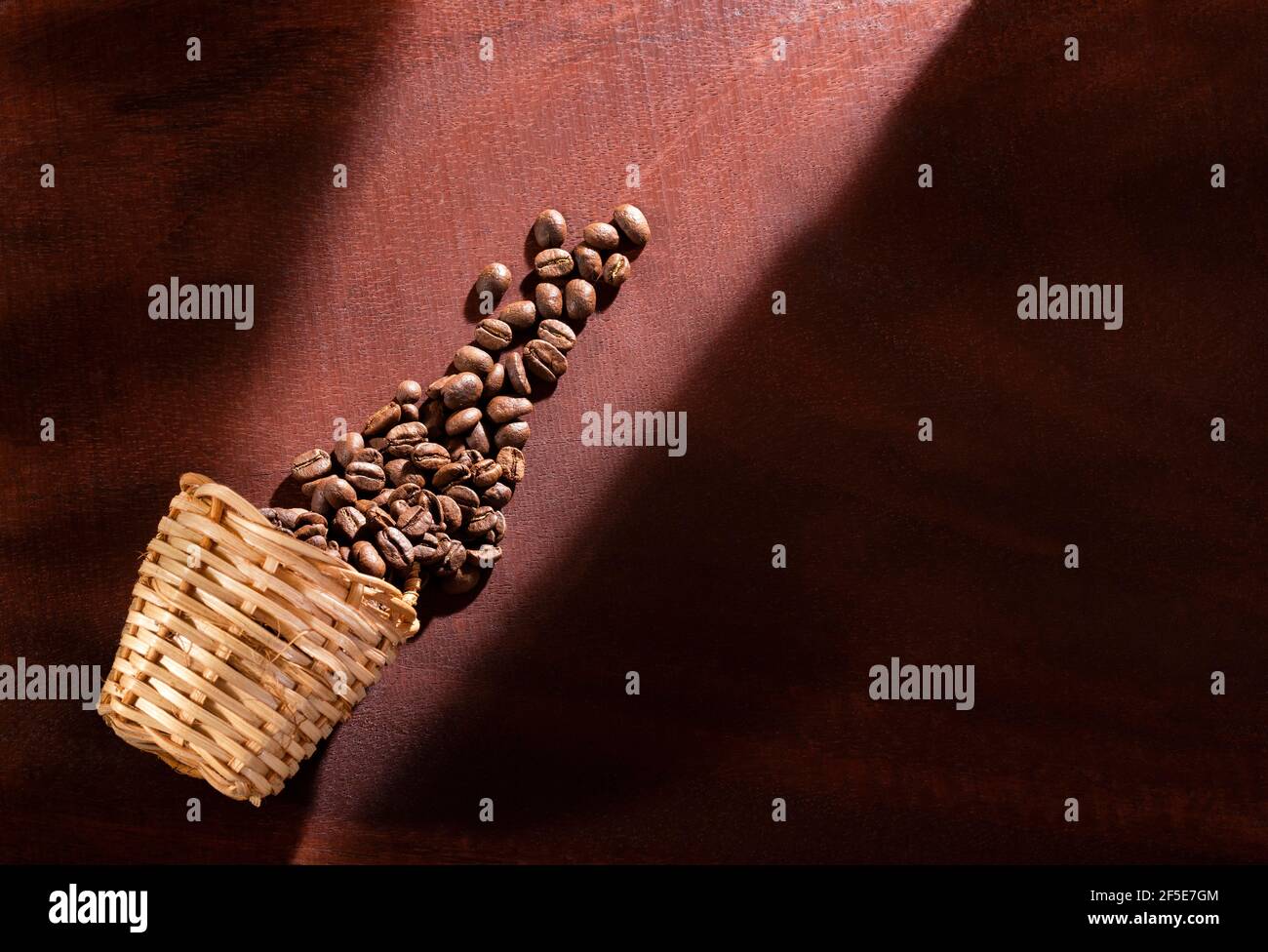 Grains de café rôtis dans le panier en osier - Coffea Banque D'Images