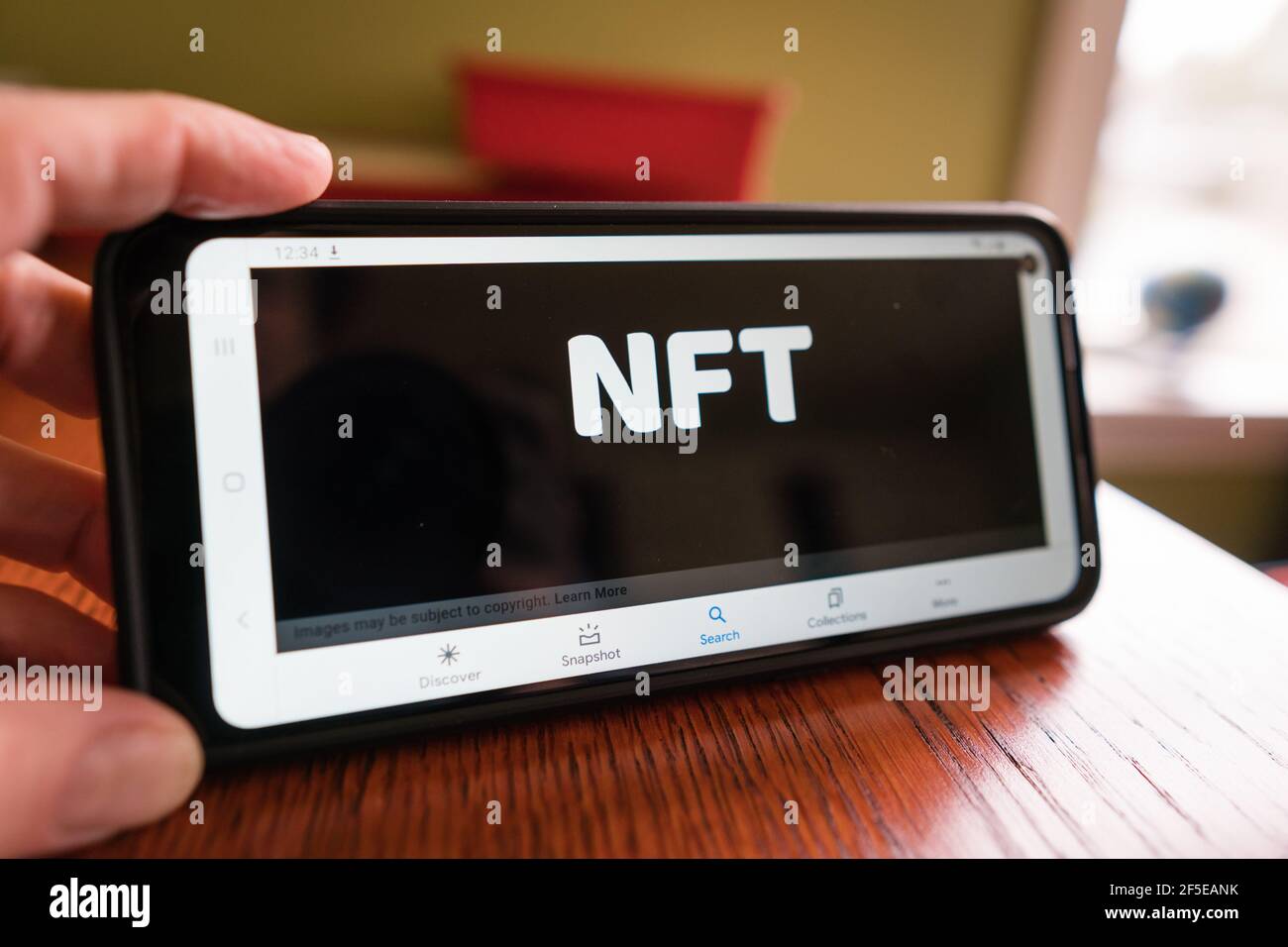 Andover, ma, US-March 24, 2021: Personne tenant le téléphone avec le logo NFT dessus. Banque D'Images