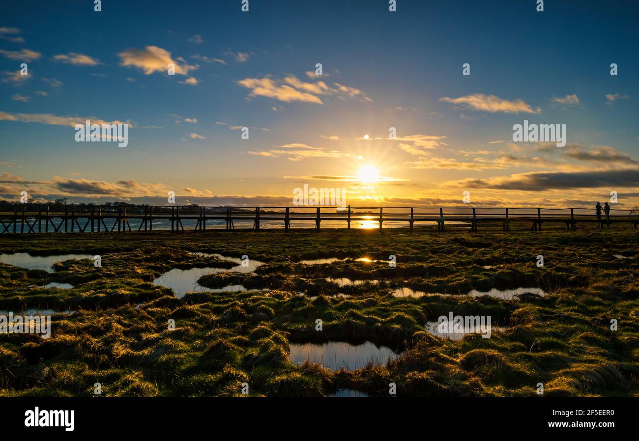 Passerelle au coucher du soleil avec nouvelle lune éclairée par le soleil couchant, Réserve naturelle d'Aberlady, East Lothian, Écosse, Royaume-Uni Banque D'Images