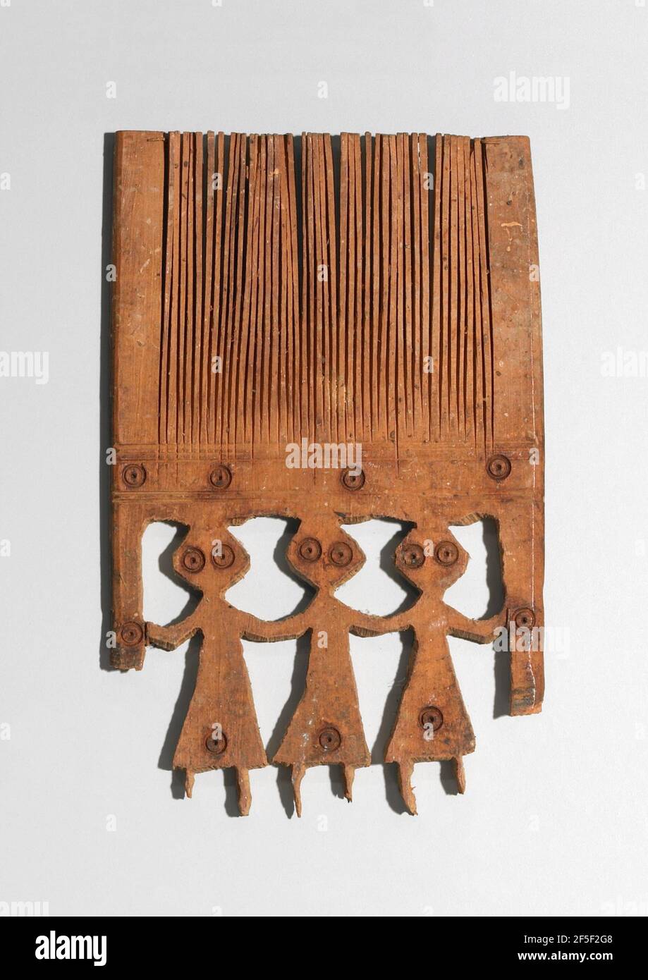 Peigne décoré de trois figurines féminines. Inconnu Banque D'Images