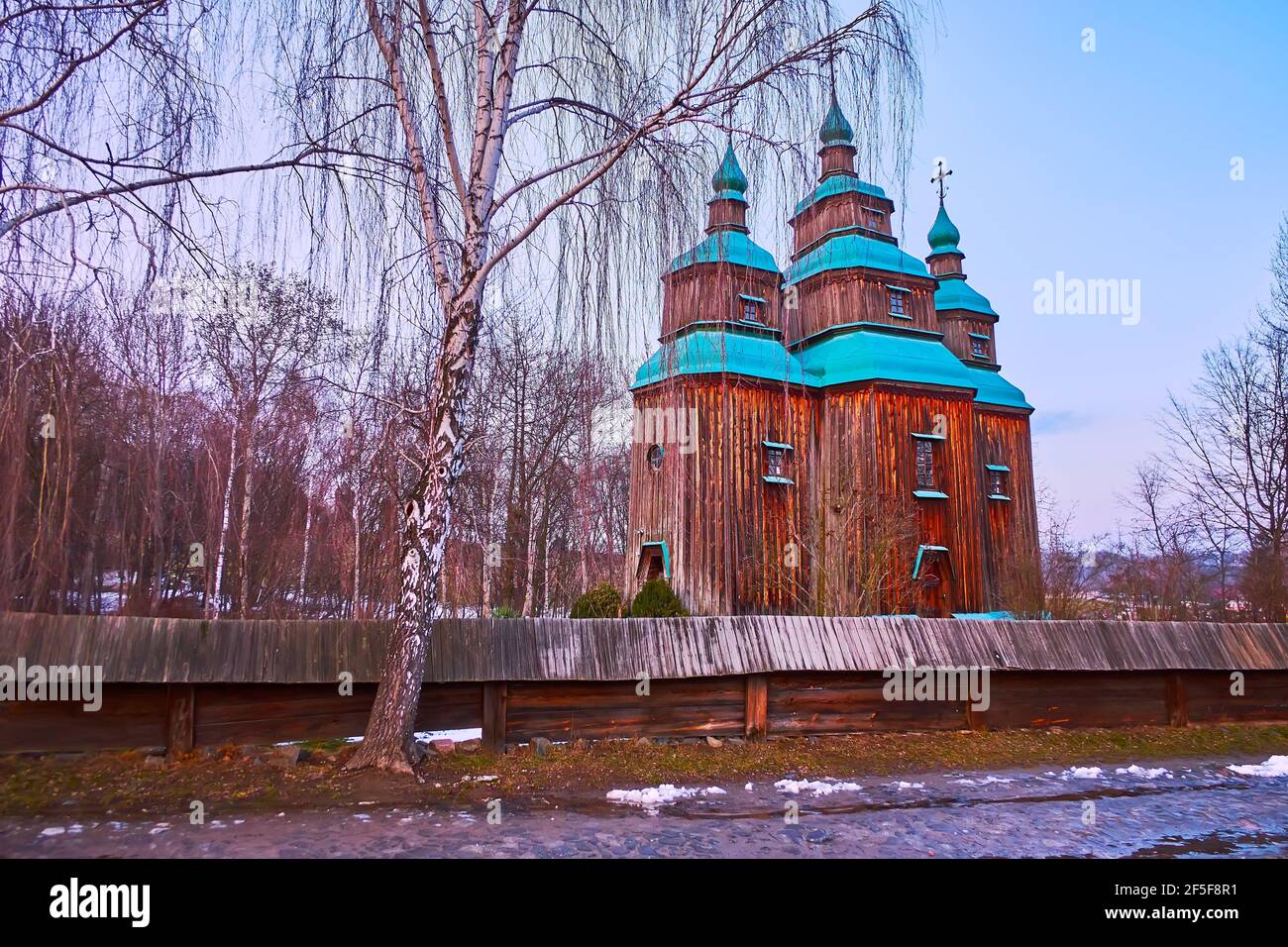 La vue de la grande église St Paraskeva derrière la clôture en bois et avec le bouleau en premier plan, Pyrohiv Skansen, Kiev, Ukraine Banque D'Images