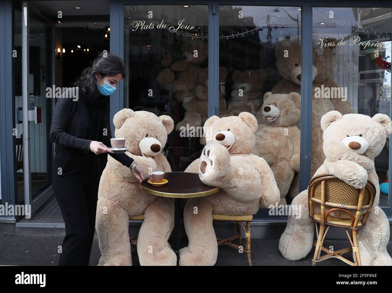 Paris, France. 26 mars 2021. Le propriétaire du café bouquet Wagram, qui  fournit des services à emporter, sert du café pour les ours en peluche  géants à Paris, en France, le 26