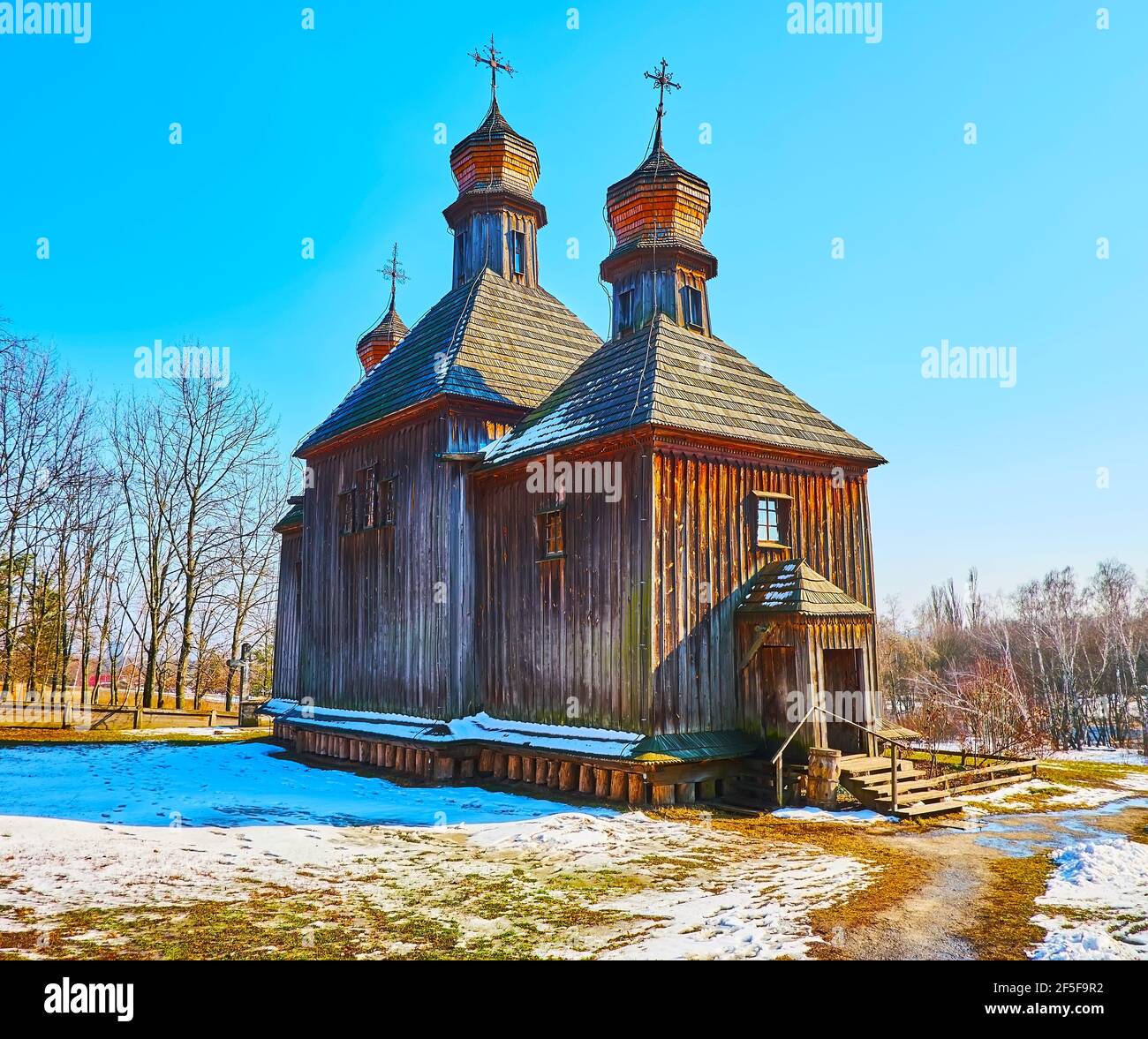 Le début du printemps à Pyrohiv Skansen - la vue de l'église médiévale St Michael au milieu de la cour enneigée, Kiev, Ukraine Banque D'Images