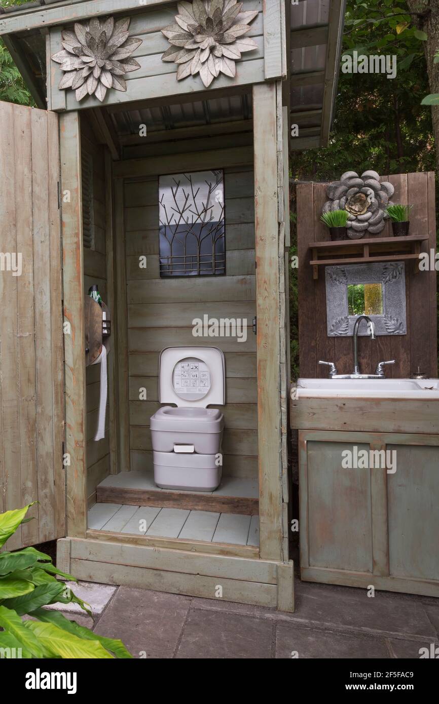 Terrasse en bois avec toilettes portables à chasse manuelle et bois armoire avec évier dans le jardin de l'arrière-cour Banque D'Images