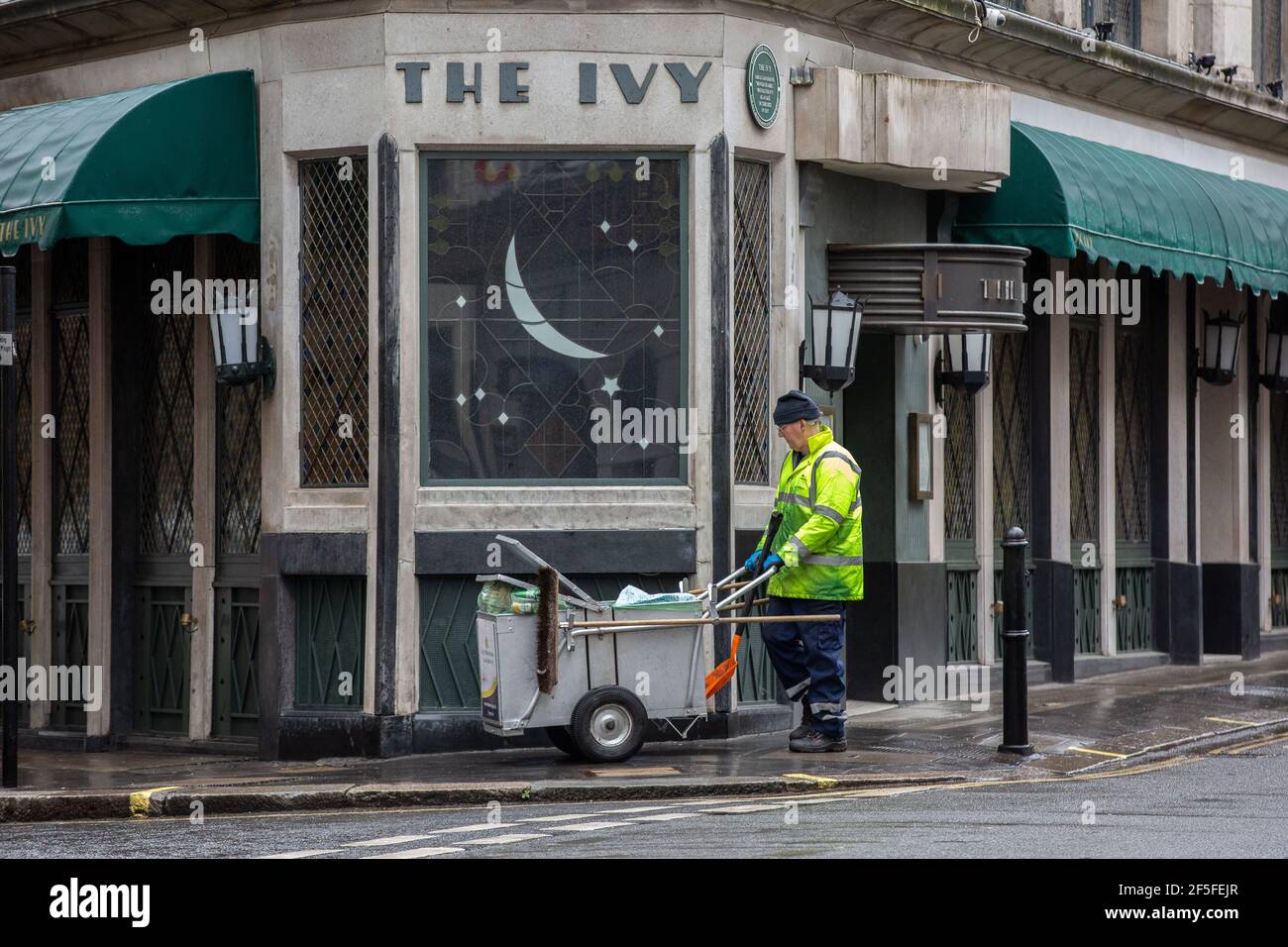 Le balai de route passe par l'extérieur du restaurant Ivy alors qu'il reste fermé en raison des restrictions gouvernementales liées à la pandémie du coronavirus, Londres, Royaume-Uni Banque D'Images