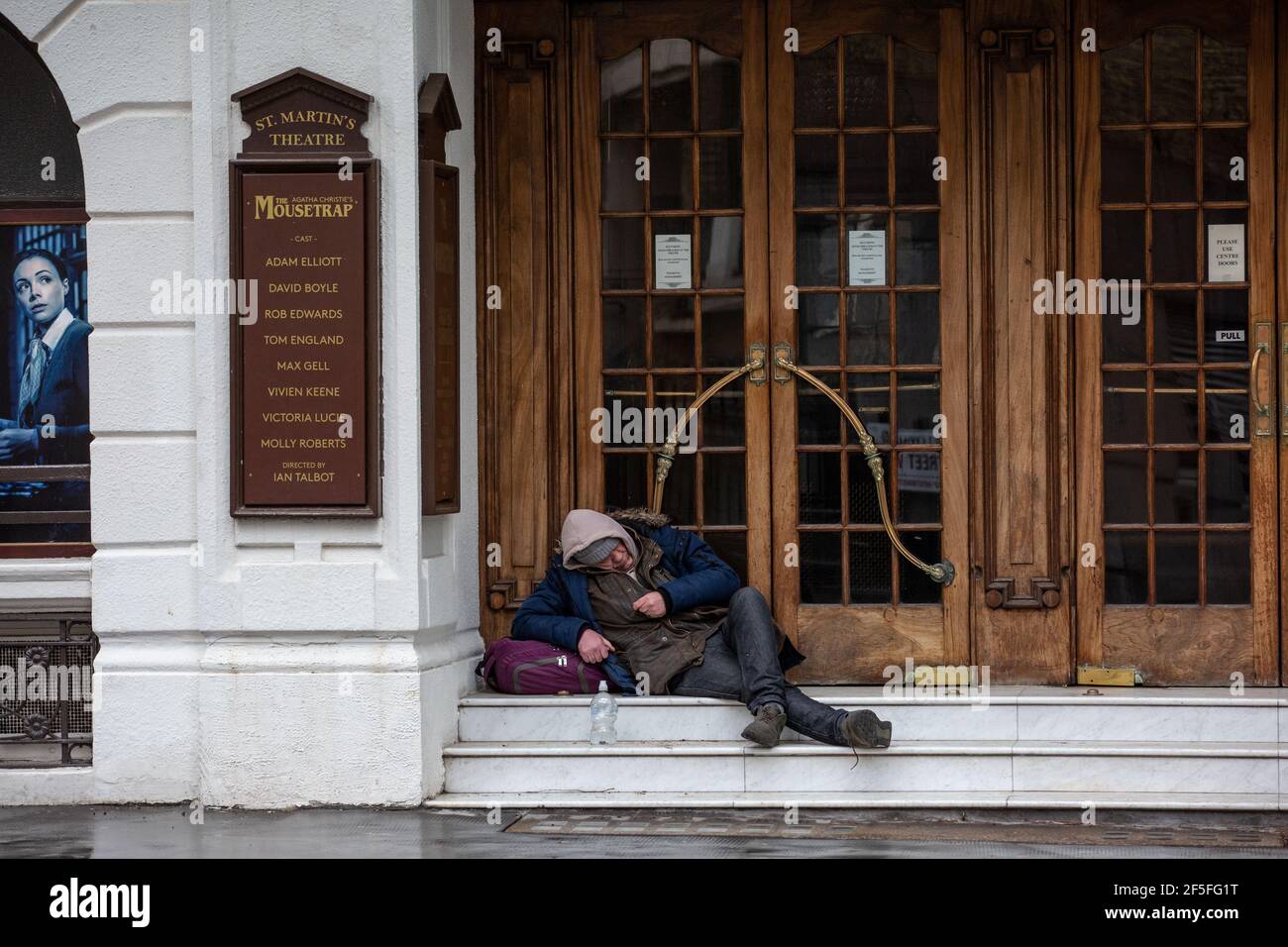 Un homme sans domicile s'assoit sur les marches du St Martin Theatre, dans le West End de Londres, avant que le coronavirus LockDown n'ait organisé la production du Mousetrap. Banque D'Images