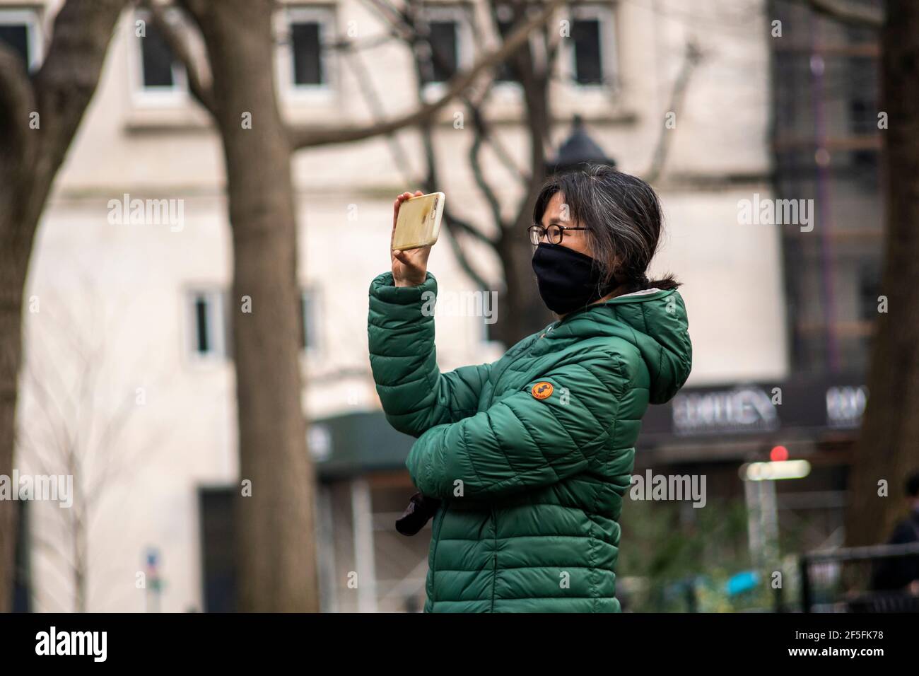 Maya Lin supervise l'installation de son œGhost Forestâ€ sur la pelouse du Madison Square Park à New York le jeudi 25 mars 2021. L'installation sensible au site se compose de cèdres morts récoltés à partir de la Pine Barrens du New Jersey et contrainera avec les arbres du parc une fois qu'ils auront fini par commencer à fleurir. L'installation aborde le changement climatique et la perte d'habitat le rappelle aux téléspectateurs de prendre des mesures. L'exposition ouvre officiellement le 10 mai et sera exposée jusqu'au 14 novembre.(Âphoto de Richard B. Levine) Banque D'Images