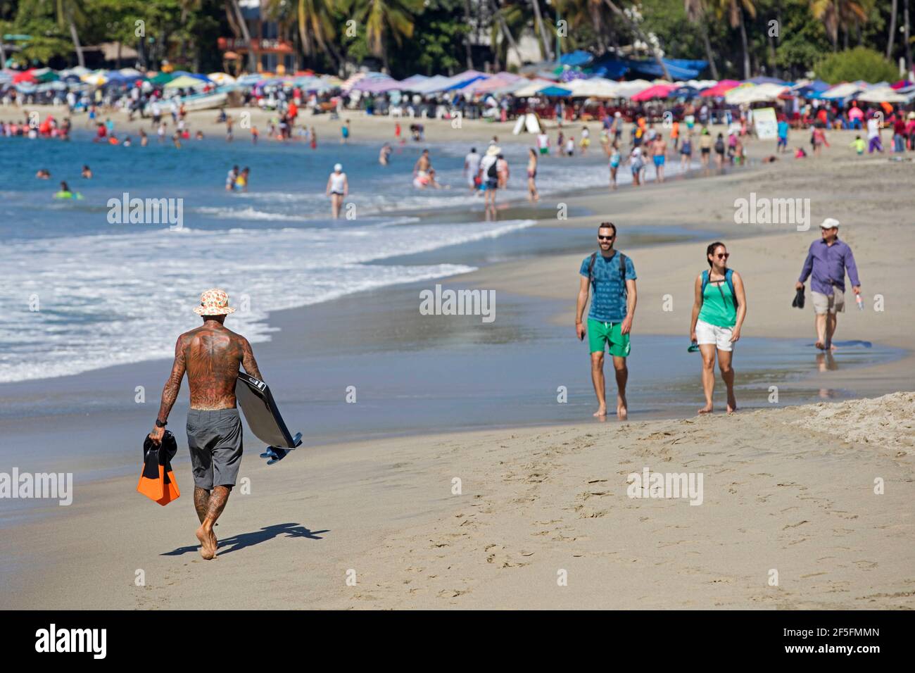 Touristes se faisant bronzer et nager à Playa principal avec plage de sable près de Puerto Escondido, San Pedro Mixtepec, Oaxaca, Mexique Banque D'Images