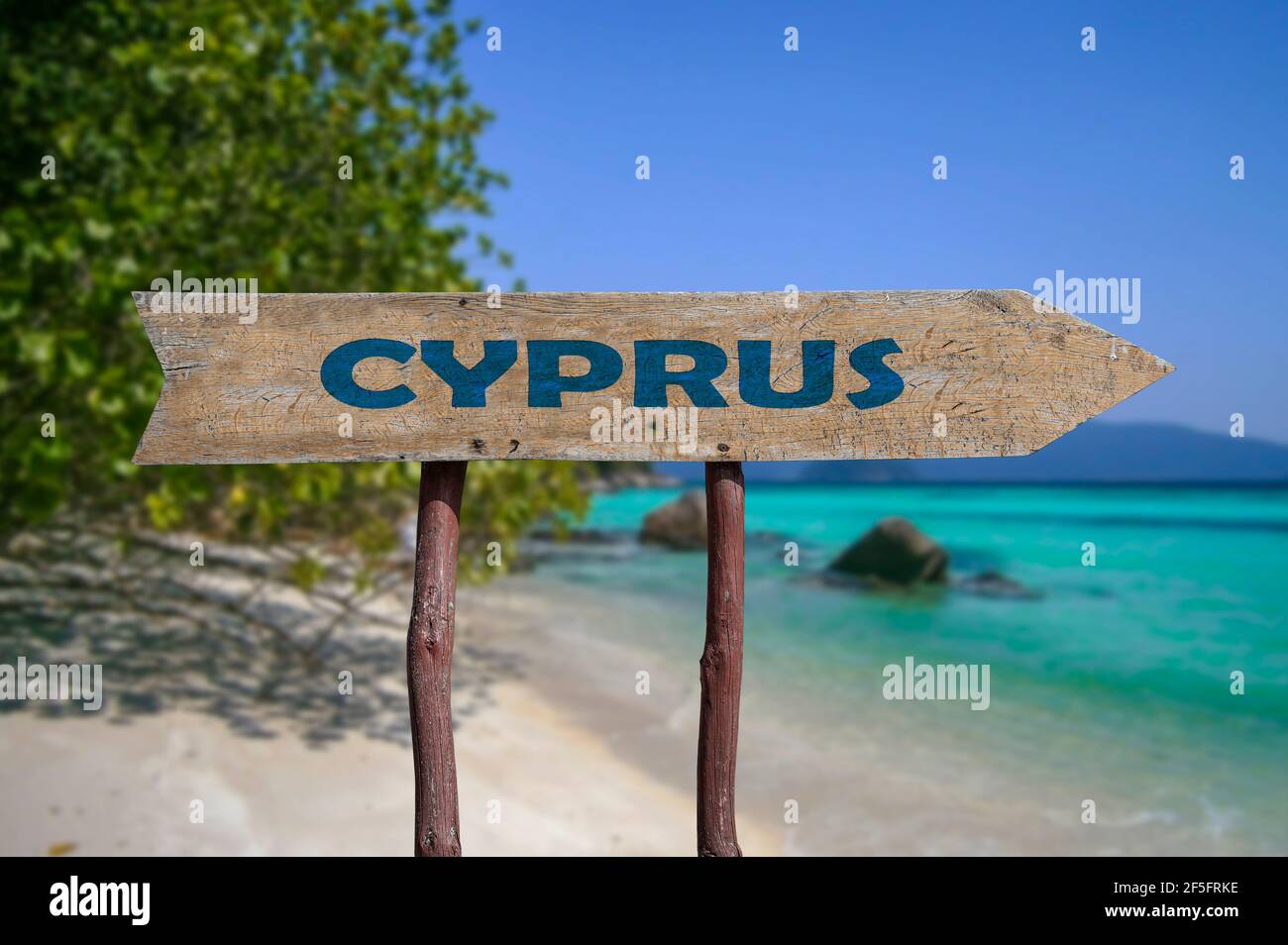 Chypre route flèche en bois signe contre la plage avec le sable blanc et l'eau turquoise fond. Voyage à Chypre concept. Banque D'Images