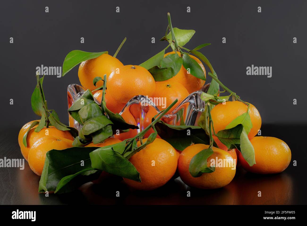 Un bol en verre débordant de mandarines sucrées et juteuses Banque D'Images