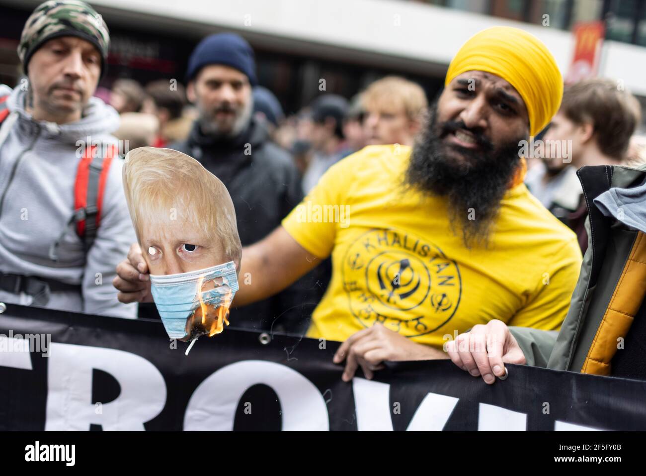 Manifestation contre le confinement et la vaccination contre Covid-19, Londres, 20 mars 2021. Les manifestants brûlent un masque de Boris Johnson. Banque D'Images