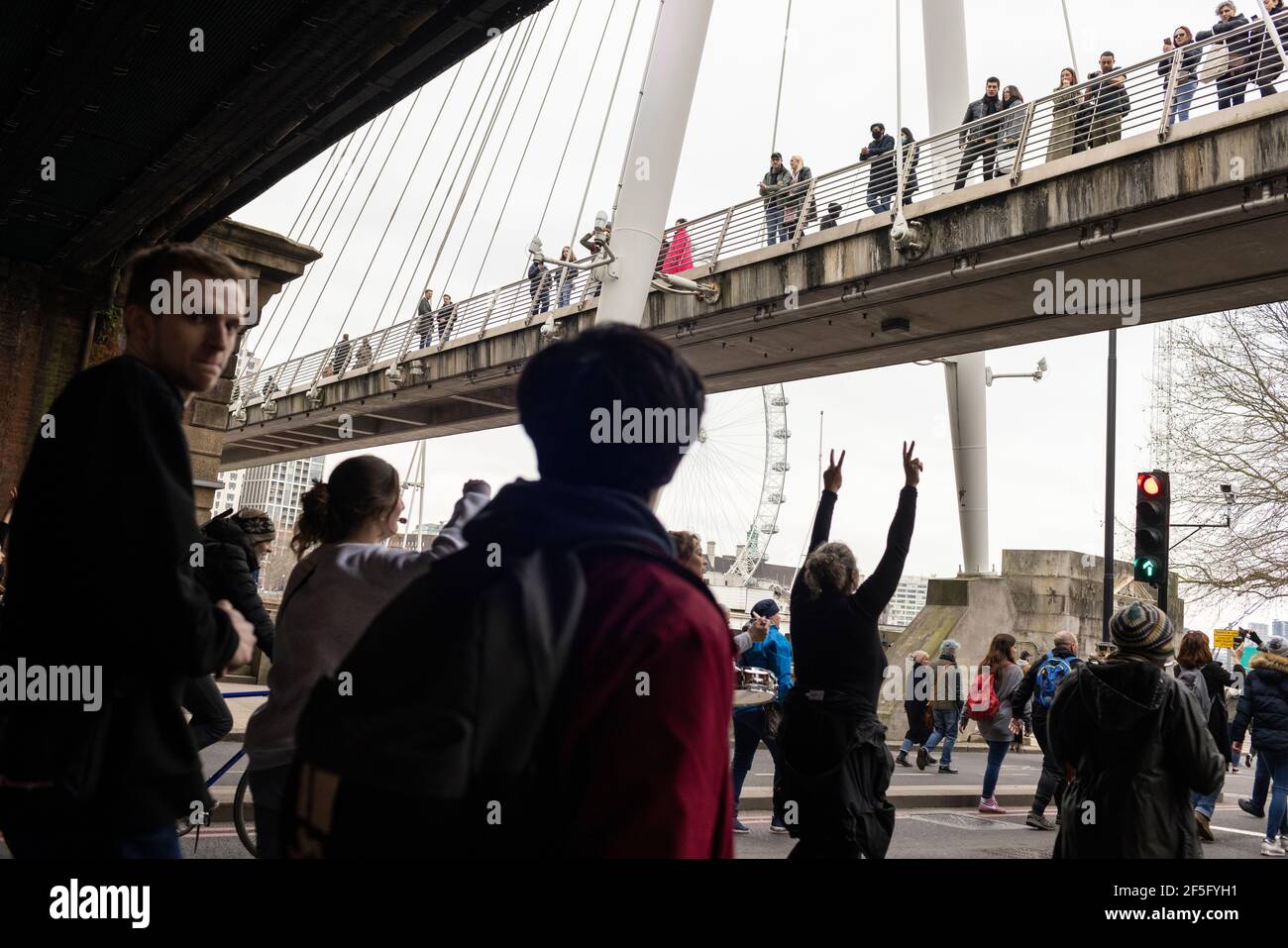 Manifestation contre le confinement et la vaccination contre Covid-19, Londres, 20 mars 2021. Spectateurs sur le pont observant les manifestants en contrebas. Banque D'Images