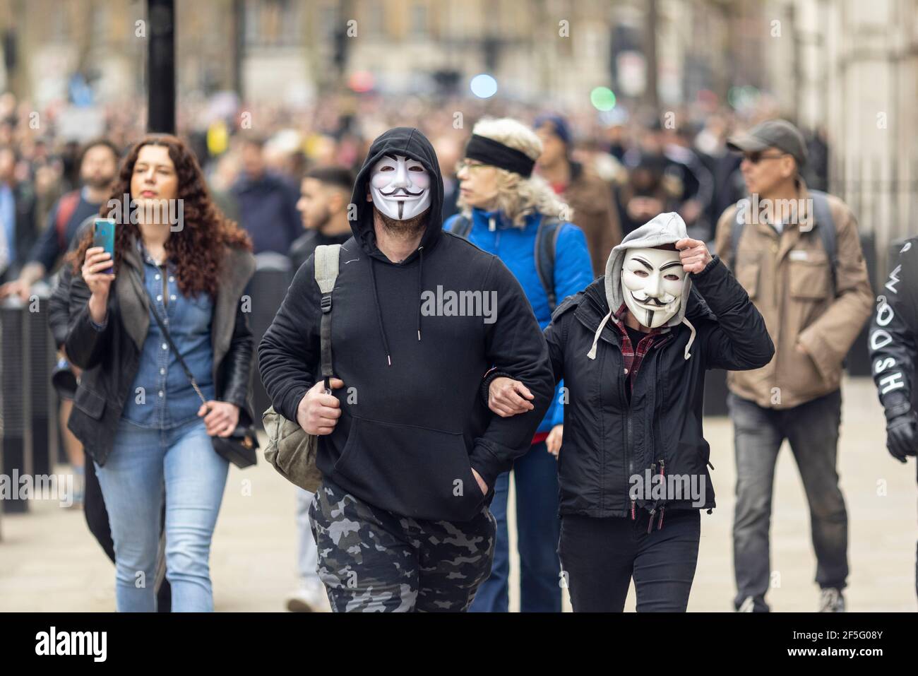 Manifestation contre le confinement et la vaccination contre Covid-19, Londres, 20 mars 2021. Marche des manifestants dans les masques Guy Fawkes. Banque D'Images
