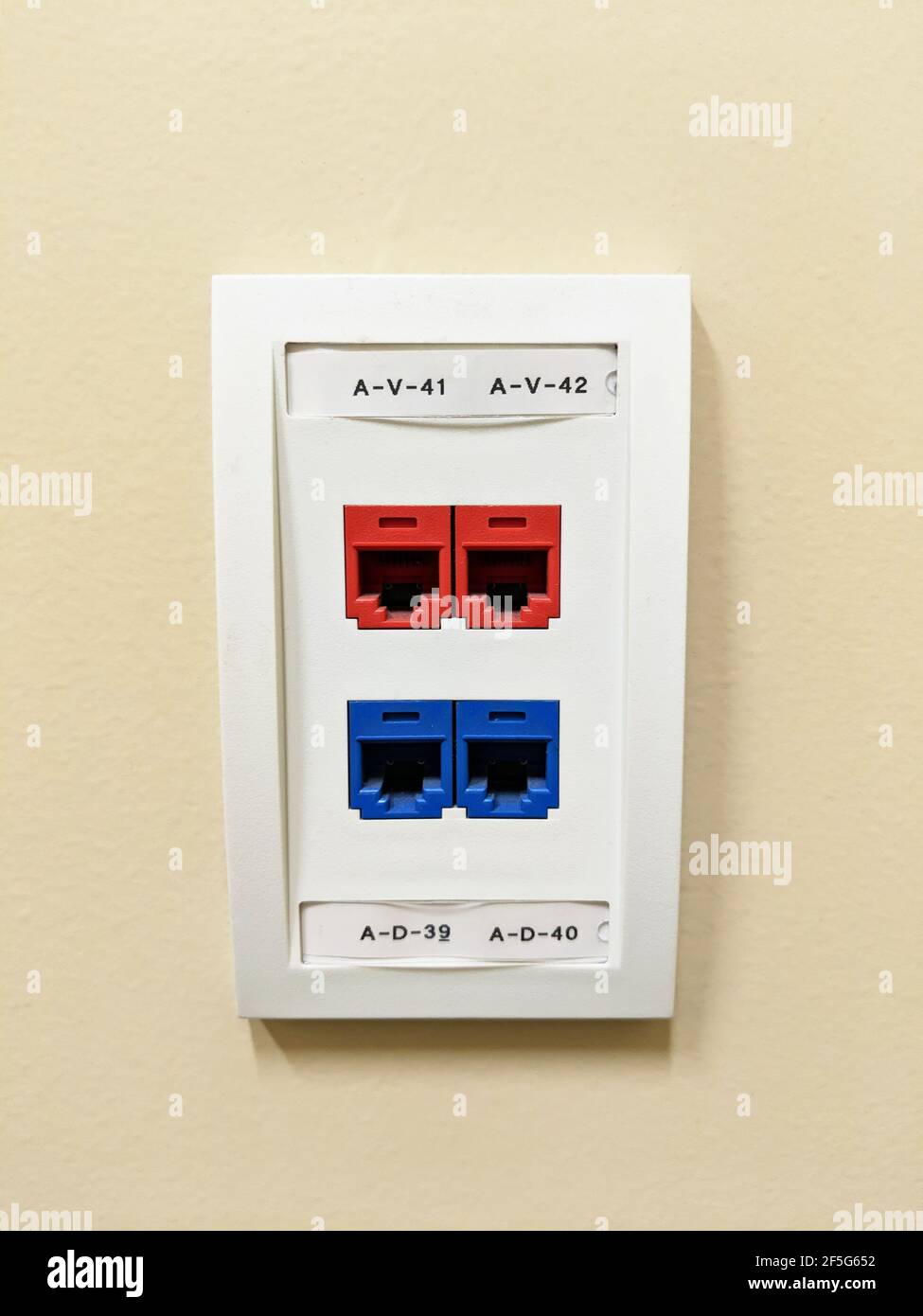 Gros plan d'une prise réseau Ethernet murale jaune. Banque D'Images