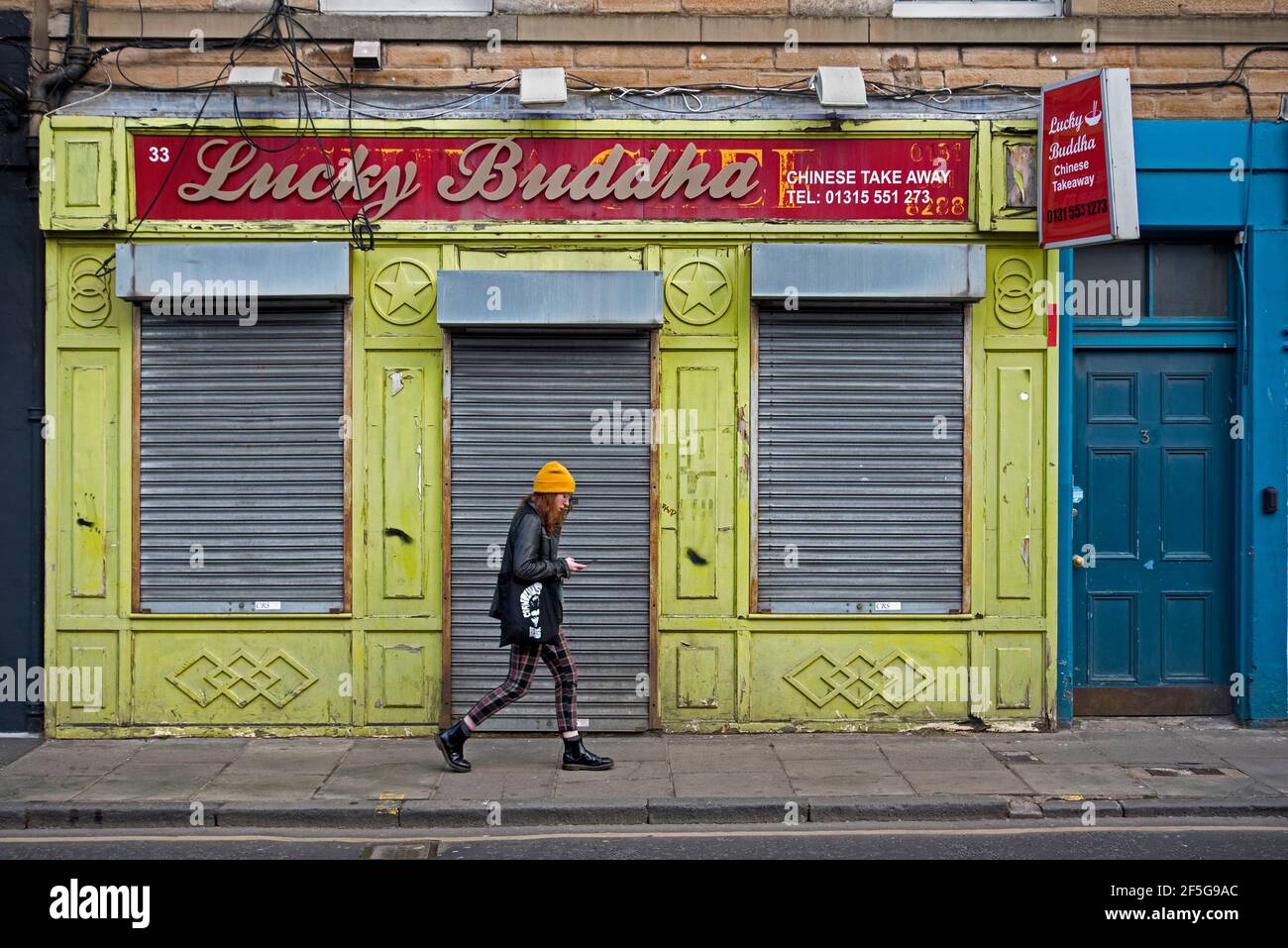 Jeune femme marchant à côté du Lucky Buddha à emporter chinois à Duke Street, Leith, Édimbourg, Écosse, Royaume-Uni. Banque D'Images Jeune femme marchant à côté du Lucky Buddha à emporter chinois à Duke Street, Leith, Édimbourg, Écosse, Royaume-Uni. Banque D'Images