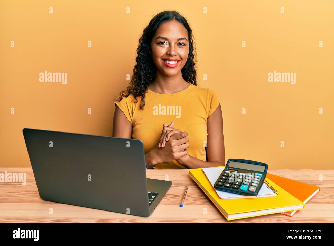 Jeune fille afro-américaine travaillant au bureau avec un ordinateur ...