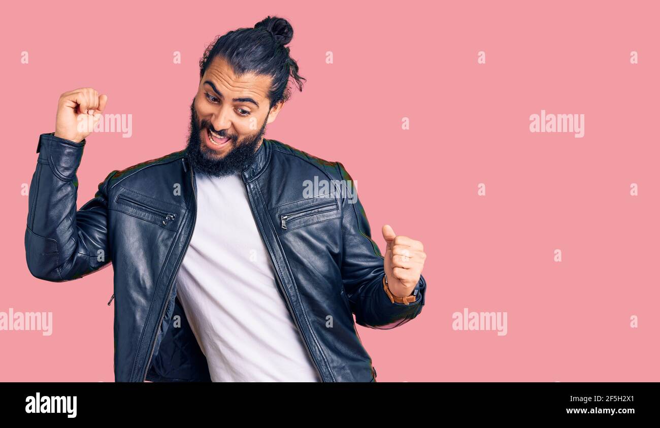 Jeune homme arabe portant une veste en cuir décontracté dansant heureux et  gai, souriant bouger décontracté et confiant écouter de la musique Photo  Stock - Alamy