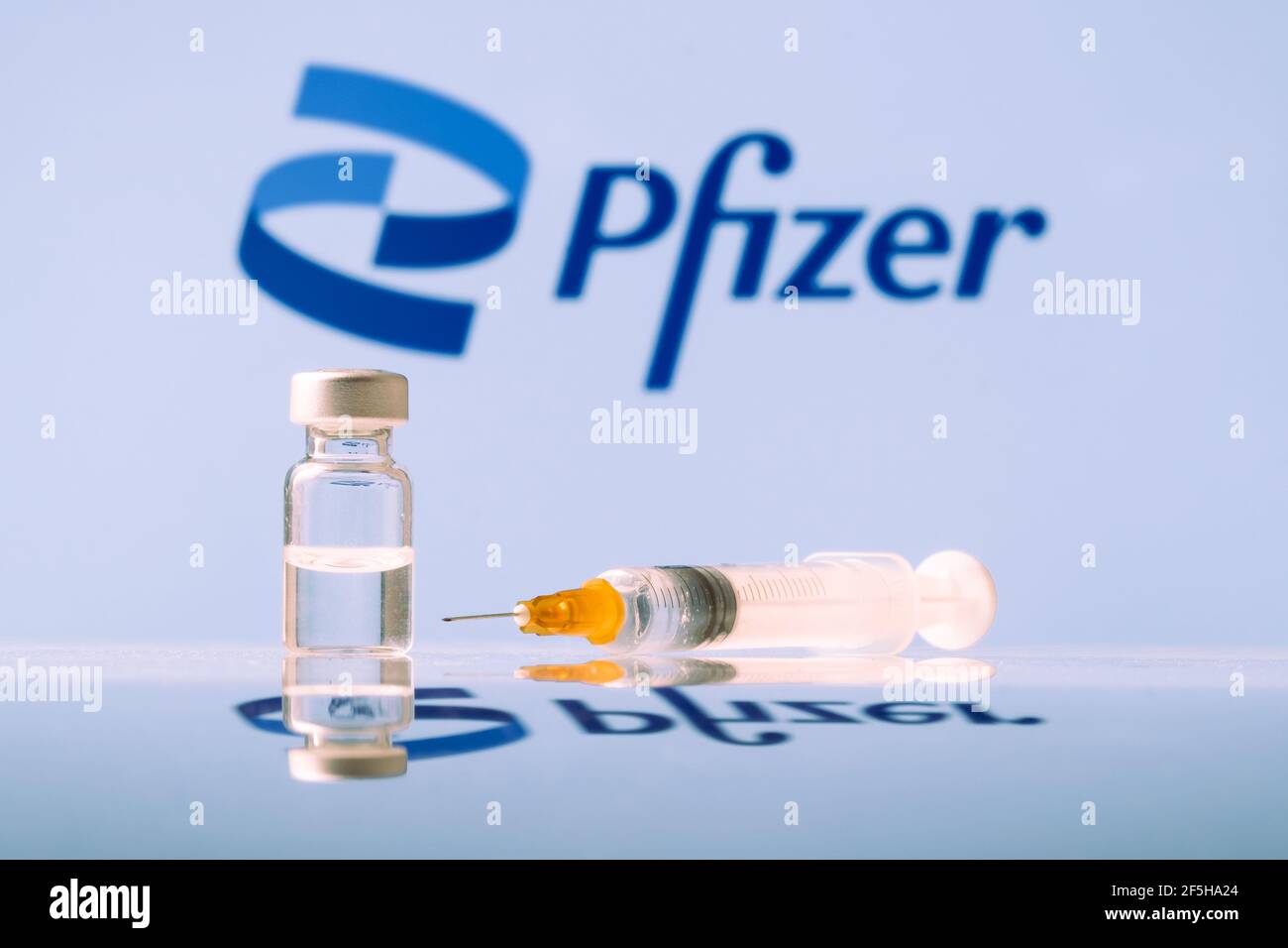 Flacon et seringue de vaccin contre le coronavirus Pfizer avec logo en arrière-plan. LJUBLJANA, SLOVÉNIE : 25 mars 2021 Banque D'Images