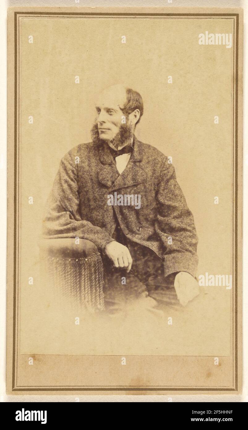 Homme non identifié avec de longues et bushy muttonchops, assis dans une chaise avec des glands. Alexander Gardner (américain, né en Écosse, 1821 - 1882) Banque D'Images
