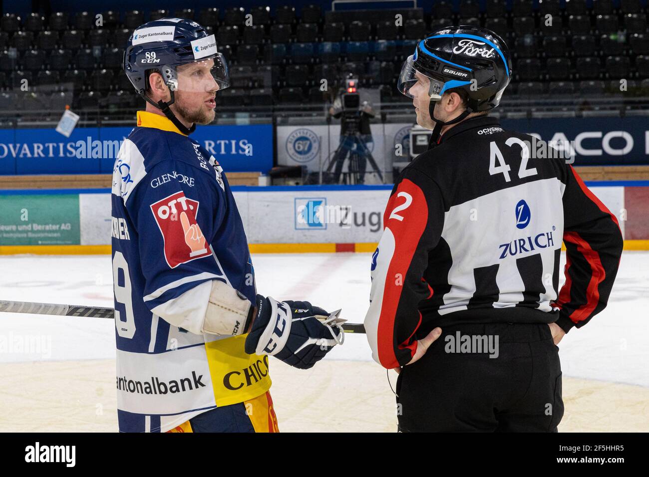 Justin Abdelkader # 89 (EV Zug) avec deux buts et quatre amendes de banc discute avec l'arbitre Thomas Urban (42) après le match de hockey sur glace de la saison régulière de la Ligue nationale entre EV Zug et Geneve-Servette HC le 24 mars 2021 dans le Bossard Arena à Zug. (Suisse/Croatie SORTIE) crédit: SPP Sport presse photo. /Alamy Live News Banque D'Images