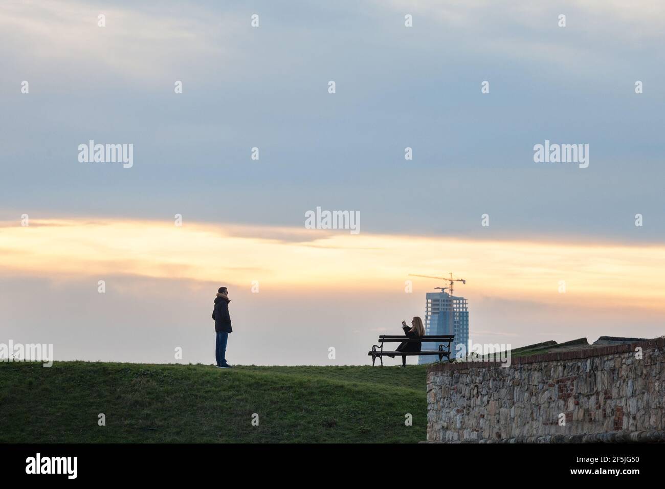 BELGRADE, SERBIE - 1er JANVIER 2021 : couple, amoureux, touristes prenant des photos et posant dans le parc de la forteresse de Kalemegdan avec un panorama de la skystra Banque D'Images