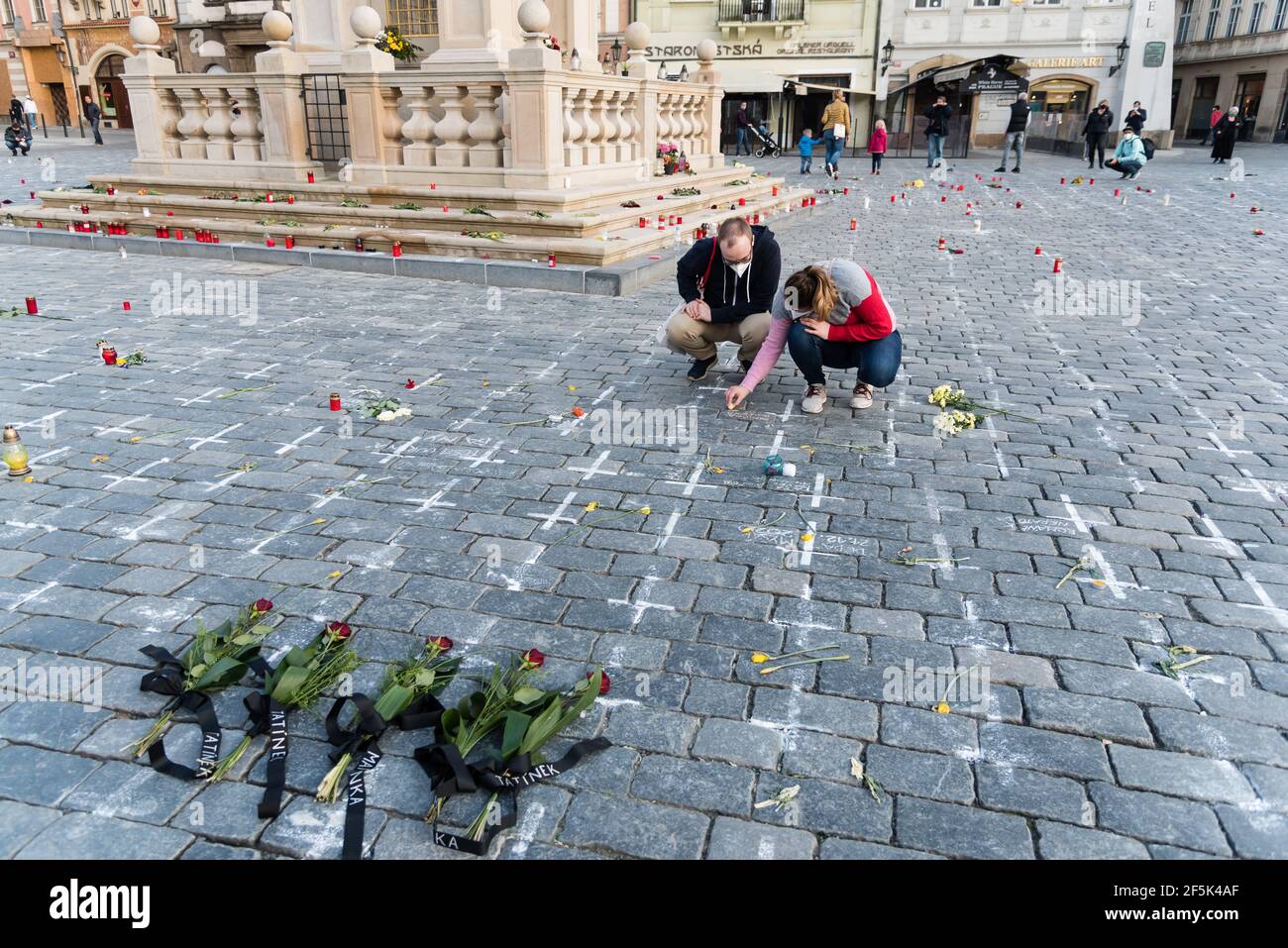 Prague, République tchèque. 26 mars 2021. Des fleurs ont été placées sur des croix pendant la commémoration.près de 25 milliers de croix et les noms des 19 victimes de covid sont temporairement peints sur la place de la vieille ville de Prague pour commémorer un an le décès du premier patient tchèque de covid 19. Crédit : SOPA Images Limited/Alamy Live News Banque D'Images