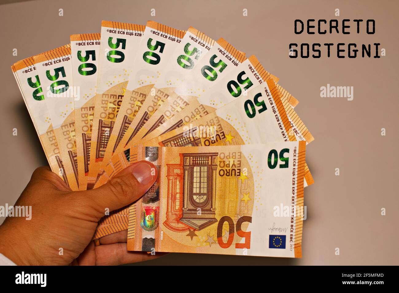 Tenir à la main des billets avec le signe 'Defreto Sostegni' traduit dans l'aide financière. Incitation du gouvernement italien. Banque D'Images