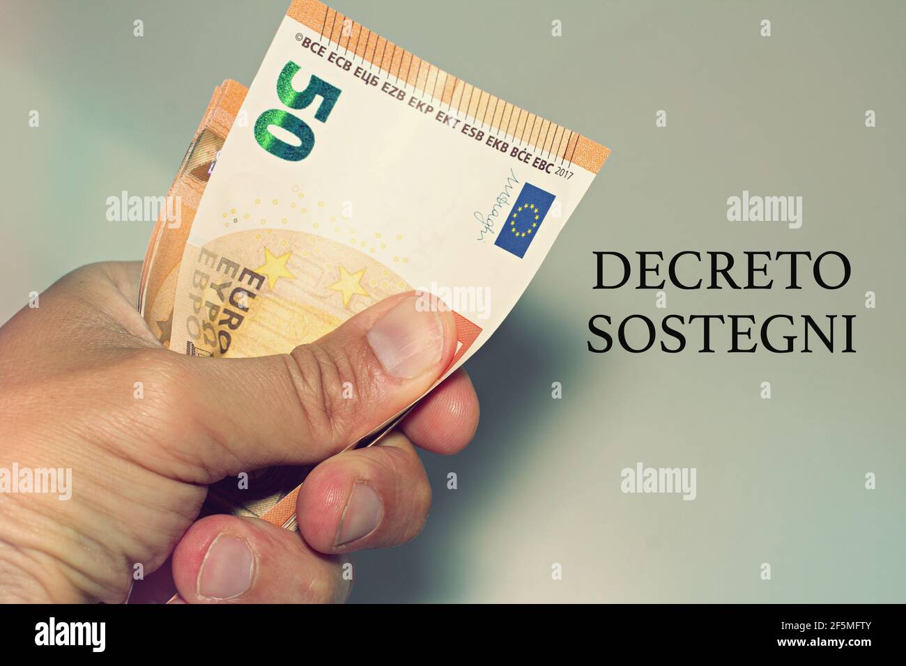 Tenir à la main des billets avec le signe 'Defreto Sostegni' traduit dans l'aide financière. Incitation du gouvernement italien. Banque D'Images