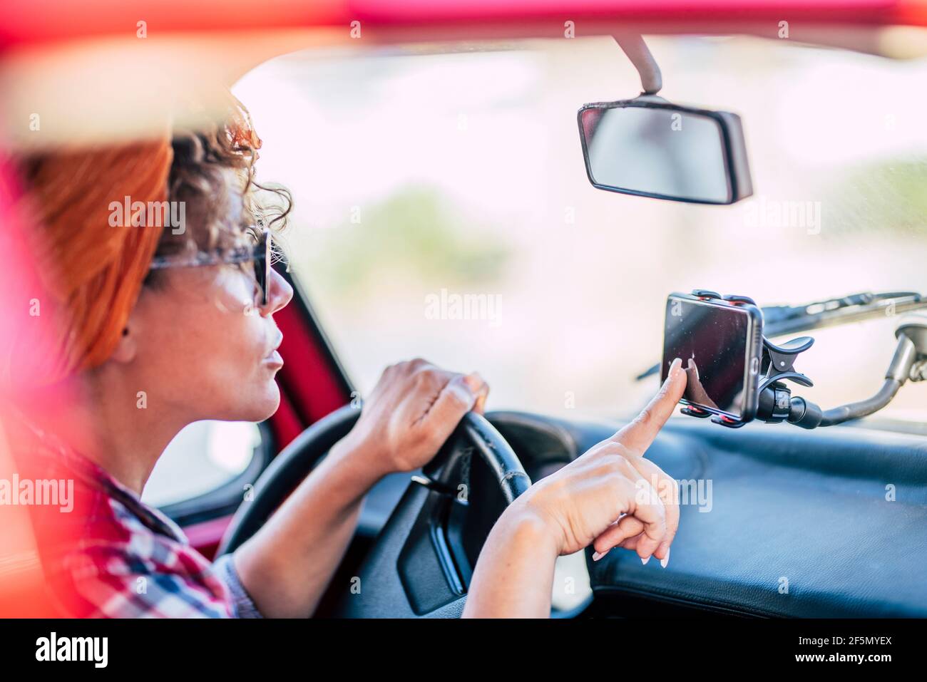 Les femmes utilisent le navigateur de cartes cellulaires par satellite à l'intérieur la voiture pour voyager et arriver destinations - femme et la technologie nav pour conduire et en Banque D'Images