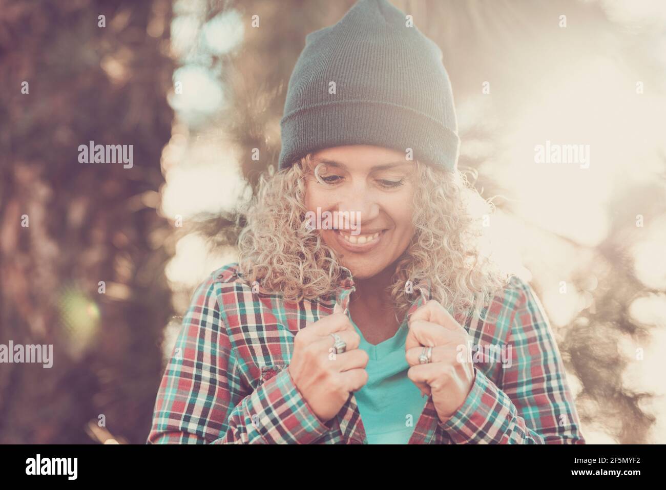 Une jeune femme adulte sourit et tient sa chemise seule la forêt bénéficiant de la lumière du soleil et activités de loisirs nature en plein air - concept de voyage de personnes et ex Banque D'Images