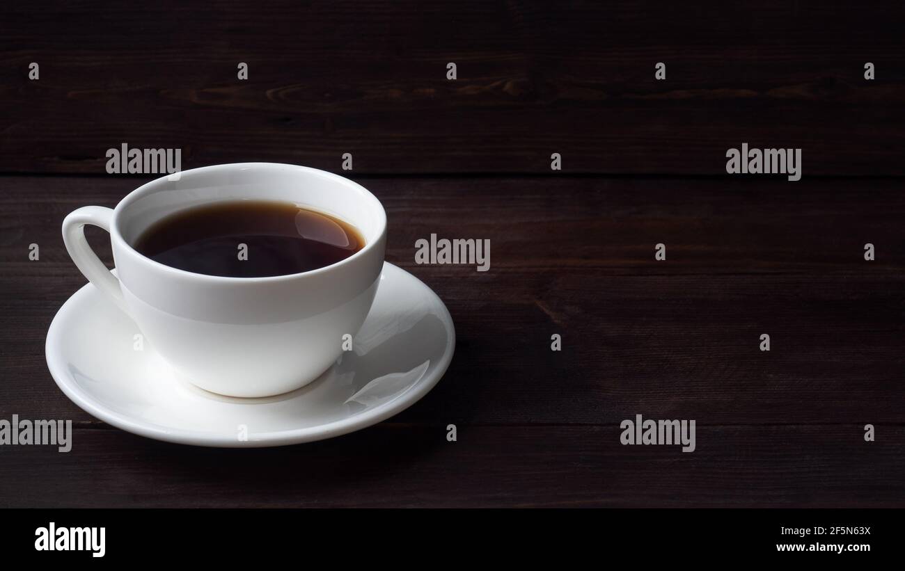 Café espresso fort noir dans une tasse en céramique blanche. Arrière-plan sombre en bois, espace de copie Banque D'Images Café espresso fort noir dans une tasse en céramique blanche. Arrière-plan sombre en bois, espace de copie Banque D'Images