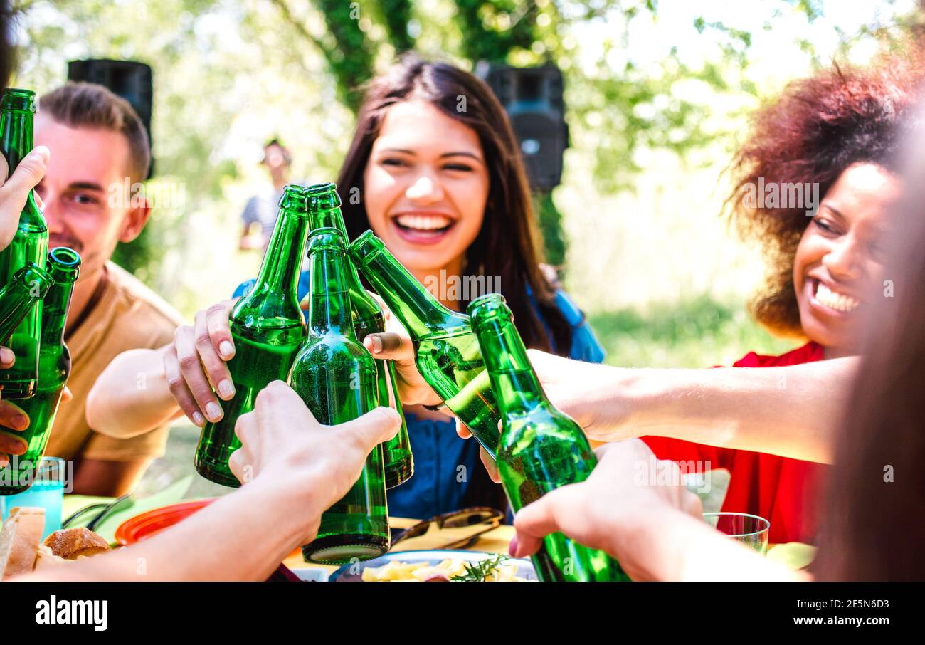 Joyeux millenial ami s'amuser au barbecue de jardin partie - Concept de style de vie et d'amitié avec les jeunes qui toasent en bouteille bière en été Banque D'Images