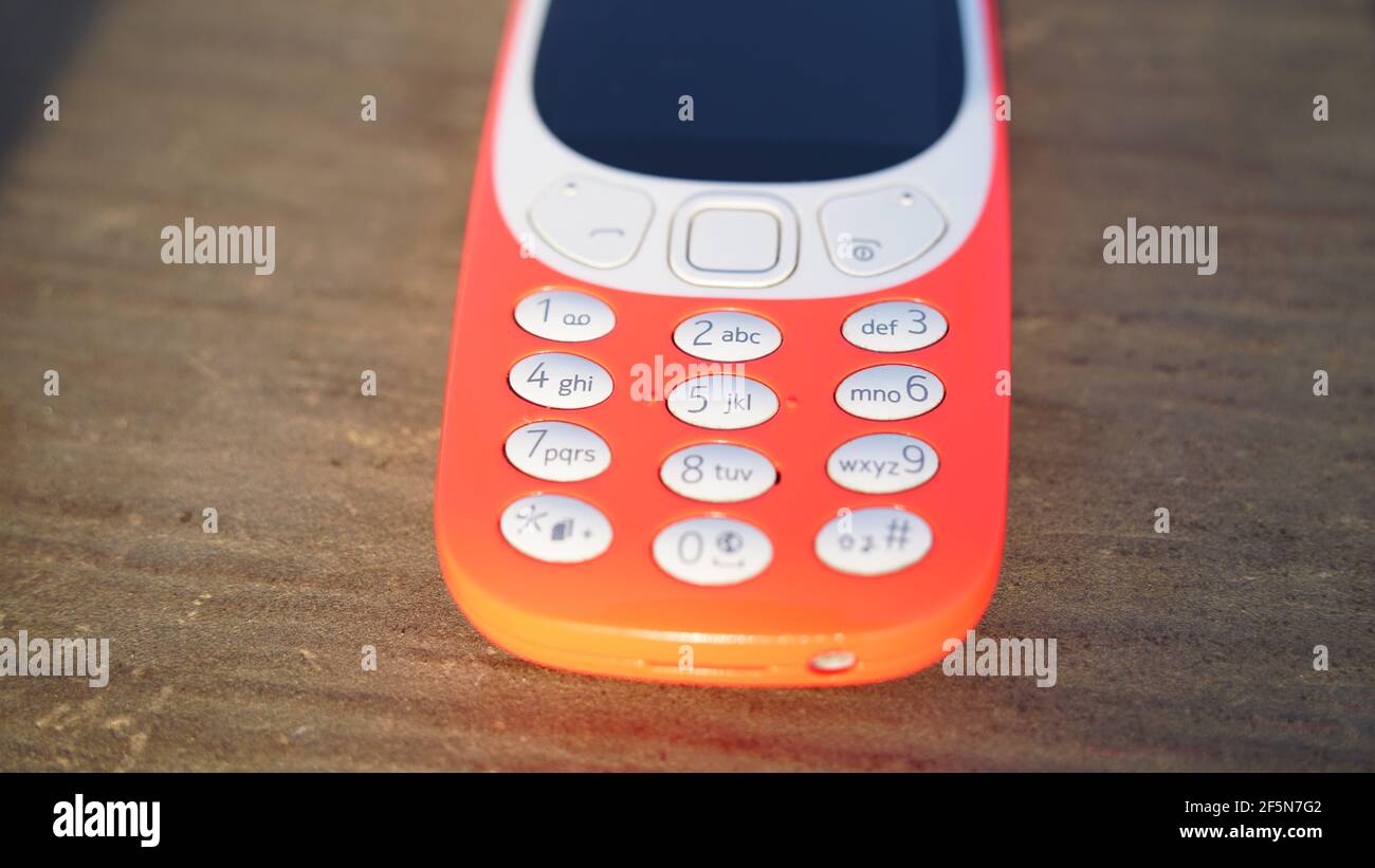 Ancien téléphone à clavier nokia 3310 isolé sur fond de table en bois. Ancien téléphone cellulaire classique avec petit écran. Société de marque Nokia en Inde. Banque D'Images