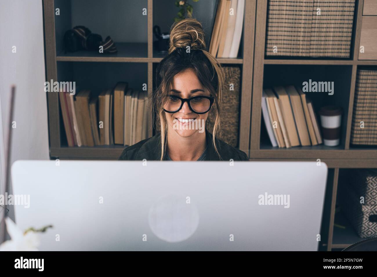 Appel de vidéo conférence en ligne travail à distance intelligent activité de bureau à domicile avec une jolie femme d'âge moyen appréciant en ligne technologie moderne et Banque D'Images