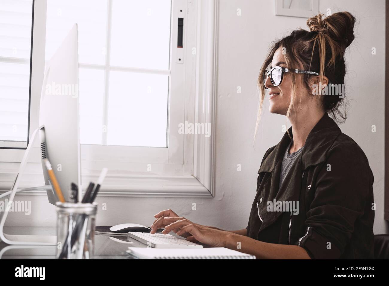 Bonne jeune femme adulte dans la vidéoconférence à la maison dans le travail intelligent, libre alternative au mode de vie de travail de bureau - joli les femmes reçoivent des nouvelles sur Banque D'Images