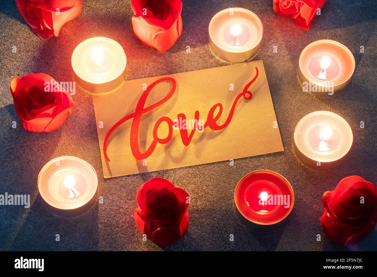 Roses rouges et bougies allumées, gros plan, carte de vœux romantique. Concept de la Saint-Valentin Banque D'Images Roses rouges et bougies allumées, gros plan, carte de vœux romantique. Concept de la Saint-Valentin Banque D'Images